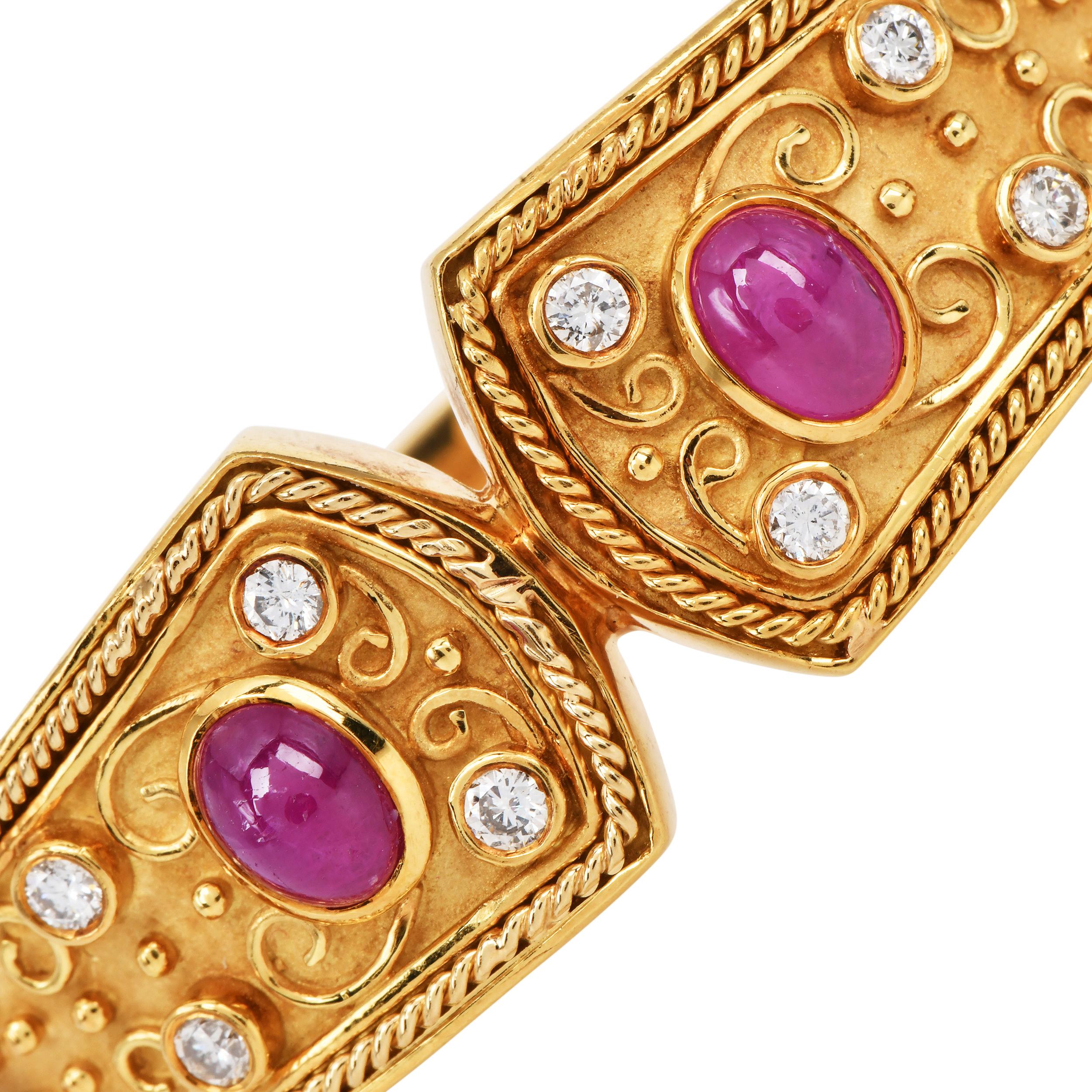 Ce remarquable bracelet en or jaune 18 carats présente des détails complexes gravés à la main, rehaussés de pierres précieuses naturelles serties en chaton. Deux rubis cabochons ovales, totalisant environ 3,00 carats, brillent de teintes rouges