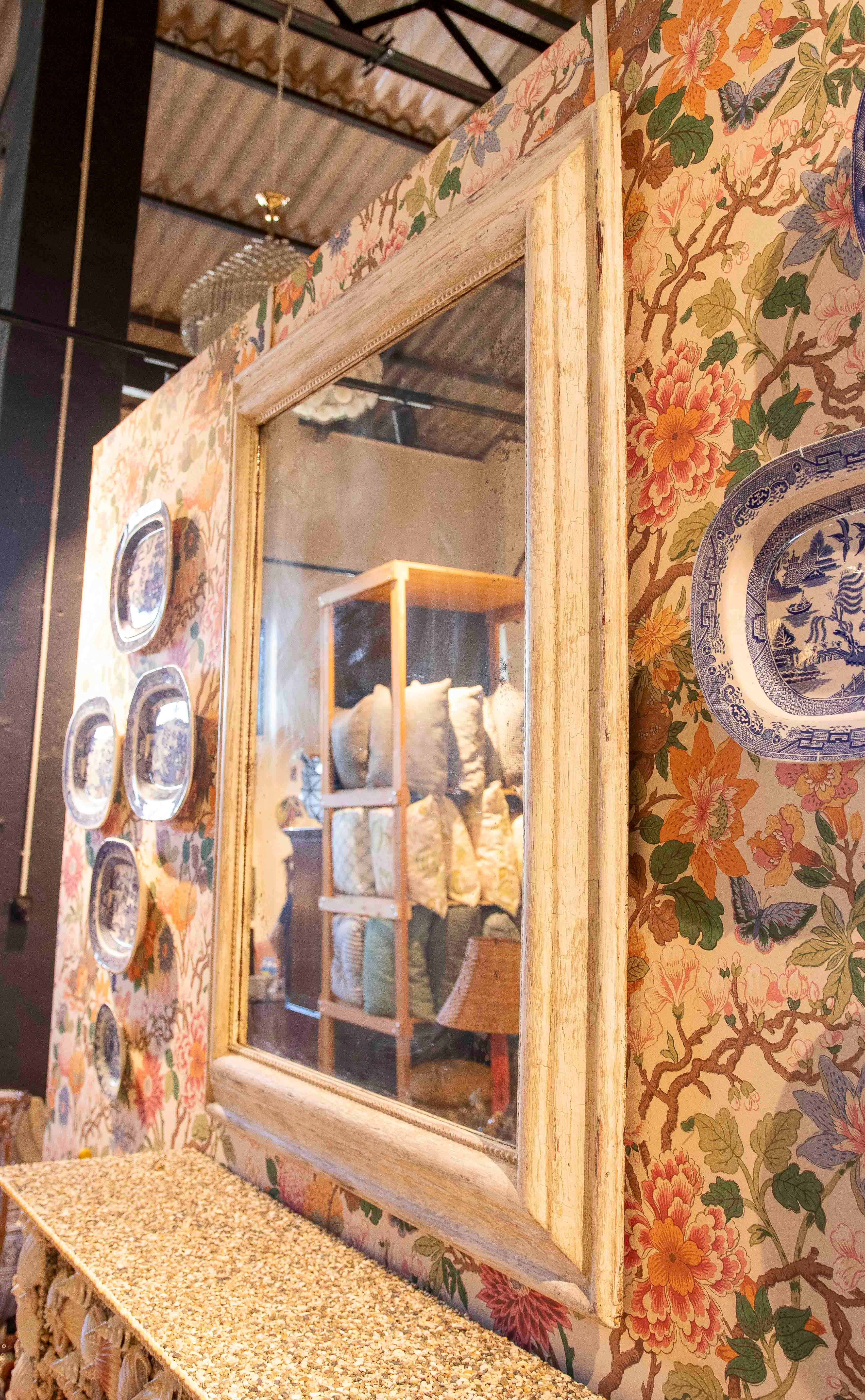 Elegante espejo con marco de madera maciza acabado en blanco envejecido, que le da un aspecto envejecido y sofisticado. El bisel interior y la moldura tallada resaltan su carácter artesanal, evocando el estilo rústico provenzal o las casas de campo
