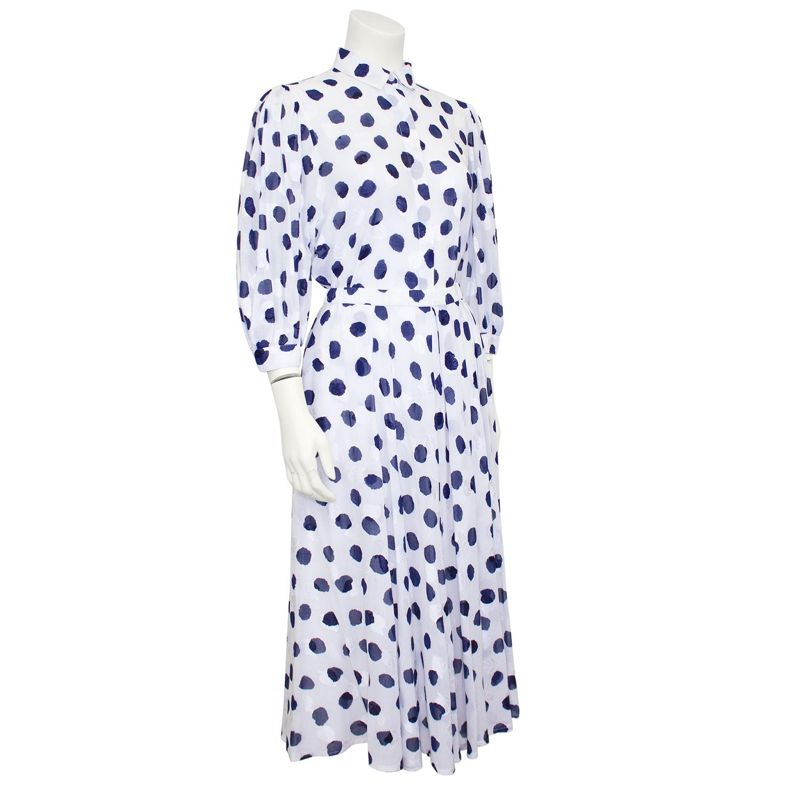 Very pretty Akris shirt and skirt set from the 1990s. Beautiful white cotton with an all over royal blue abstract polka dot print that looks hand painted. The set is further detailed with subtle white embroidered leaves. Blouse features gathered