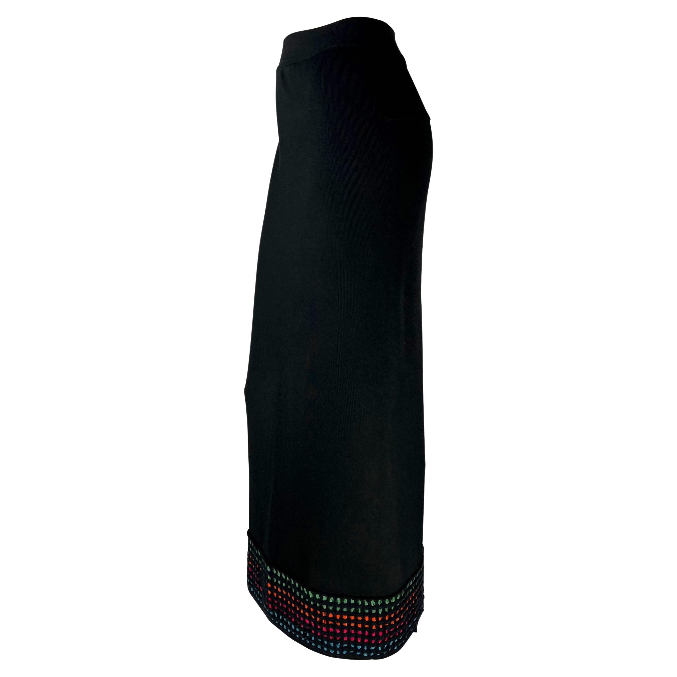 Presenting a chic black knit Azzedine Alaïa maxi skirt. From the mid 1990s, this chic black skirt perfectly clings to the body. The nearly floor-length skirt features a slit at the back waist and the hem is made complete with a spotted multi-color