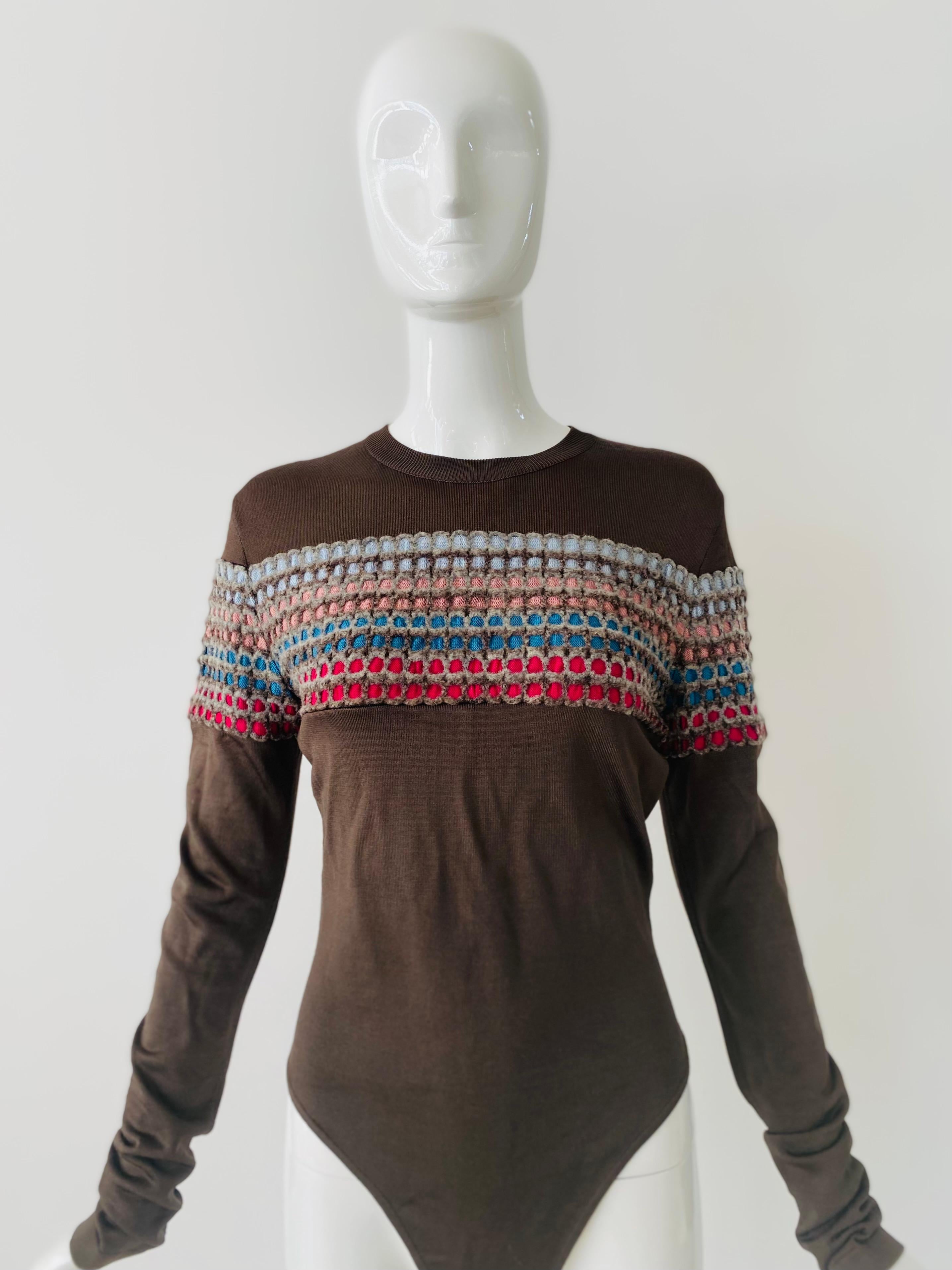 1990s iconic Alaia knit bodysuit in an olive green and rainbow honeycomb lines across the chest and upper arms.  The fabric is a mix of rayon, nylon and spandex for the classic Alaia fabric feel.  This bodysuit is labelled a M.