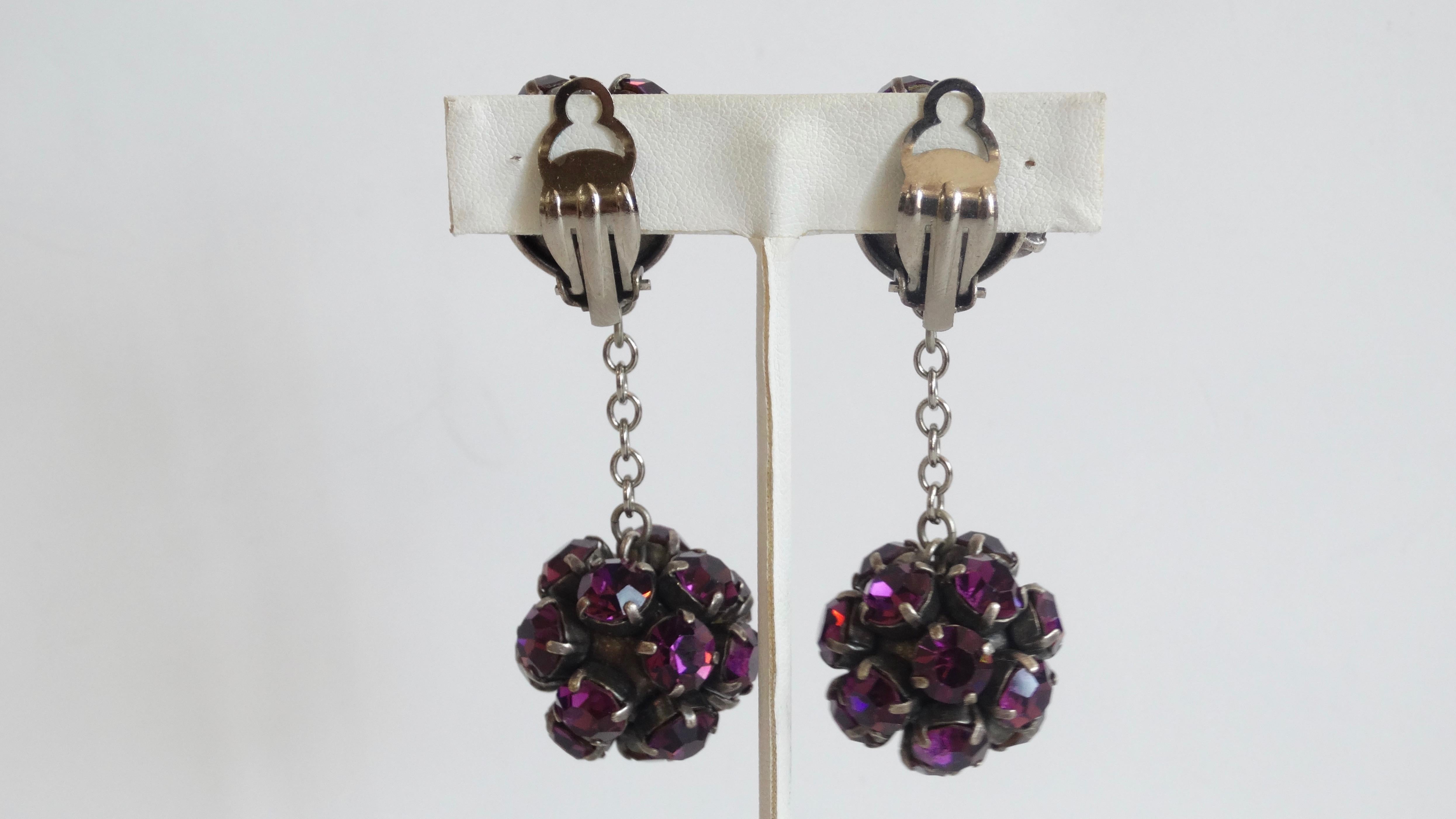 Spice up your earrings collection with these Alan Anderson earrings! Circa 1990s, these art deco inspired ball drop earrings are embellished with purple vintage rhinestones and is finished in a gun metal grey, referred to as a “Japanned” finish.