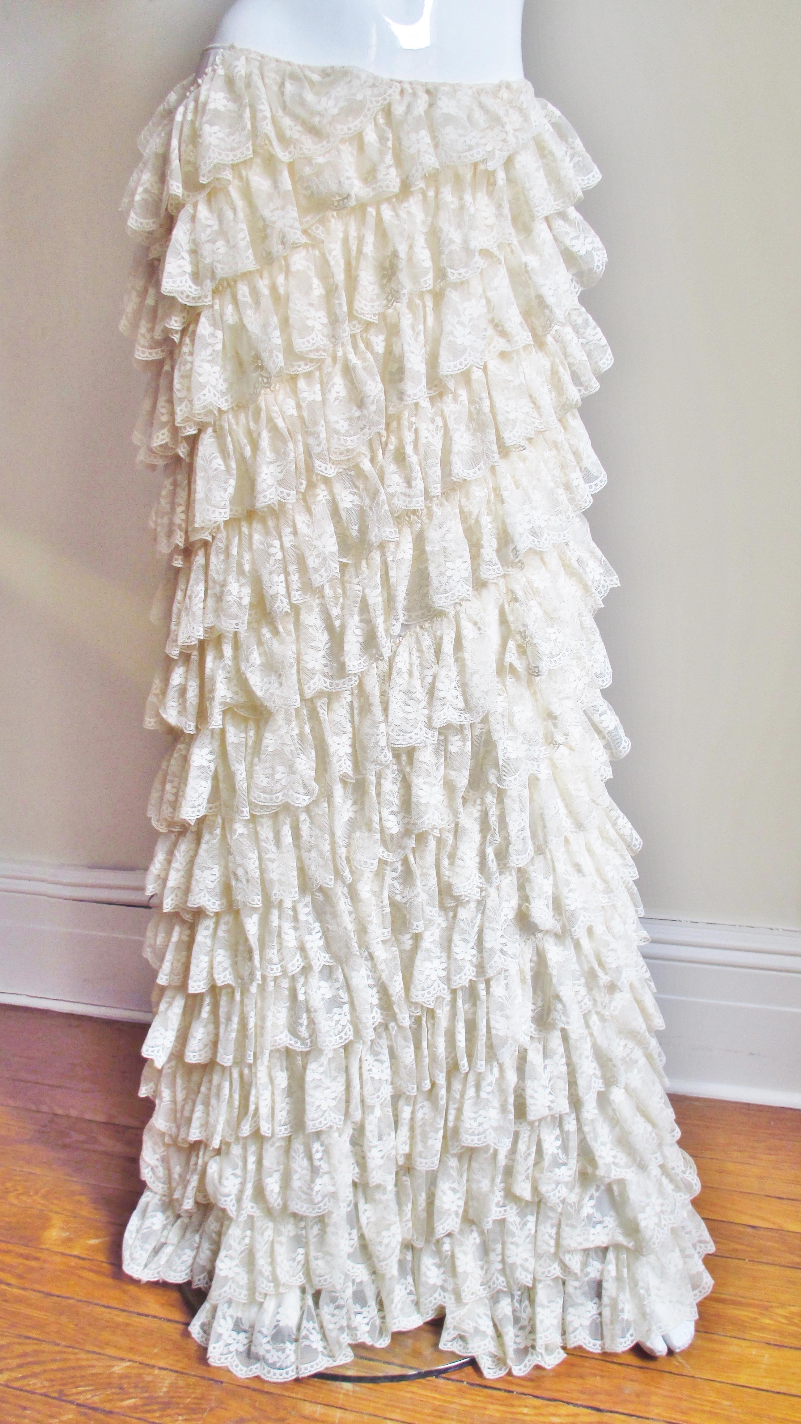 An incredible off white silk maxi skirt from the early collections of Alexander McQueen covered in rows and rows of angled cascading matching lace ruffles. The skirt is slightly longer in the back draping beautifully.  It closes with a matching side