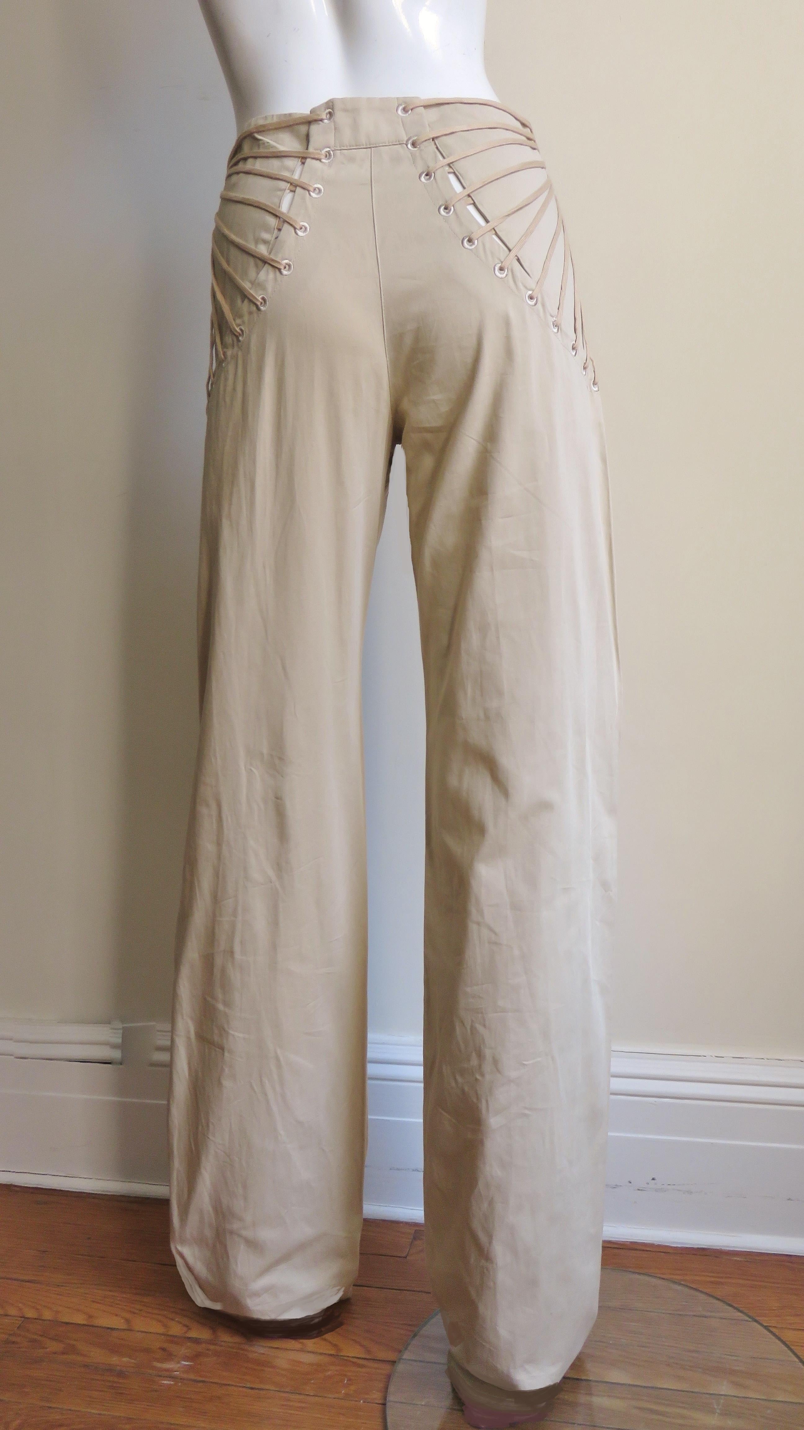 Fabulous khaki cotton pants from Alexander McQueen. They have full straight legs with curved panels over the back hips with a fan of laces meeting and buttoning on the front sides at the waist.  
Unworn condition.  Fits size Small, Medium. Marked