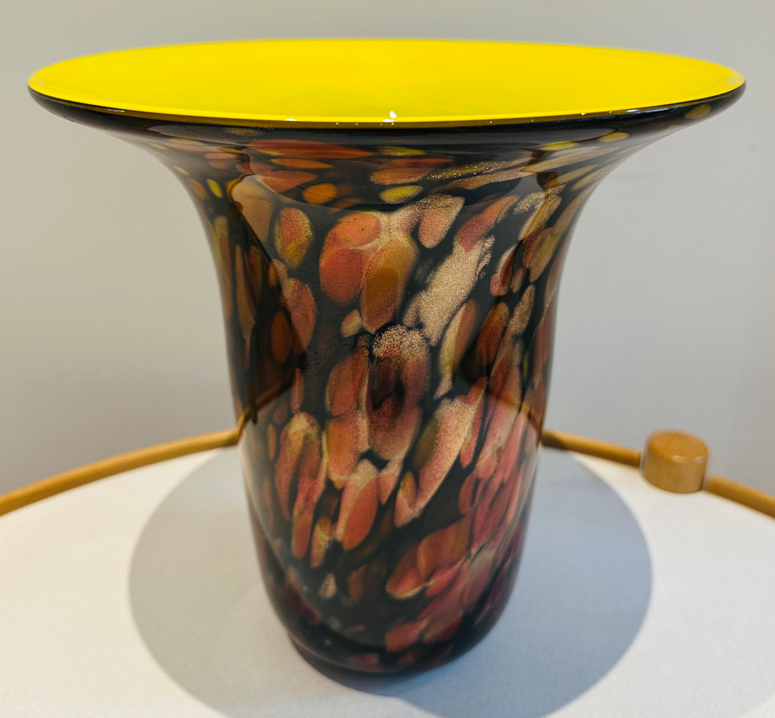 Un sorprendente vaso a forma di tromba soffiato a mano negli Stati Uniti negli anni Novanta.  Il vaso presenta un esterno in vetro avventurina nero, marrone e oro. Il vetro avventurina è noto per il suo effetto metallico scintillante, spesso
