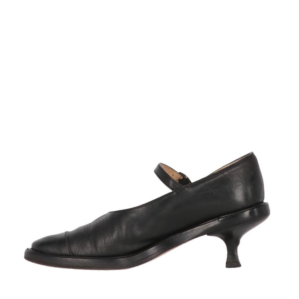 Ann Demeulemeester black genuine leather Mary Jane low-heel pumps. Strap and metal buckle, cap toe stitching, round toe, thick sole and kitten heels. 

The shoes show signs of wear on the leather and the heel, as shown in the pictures.

Years: