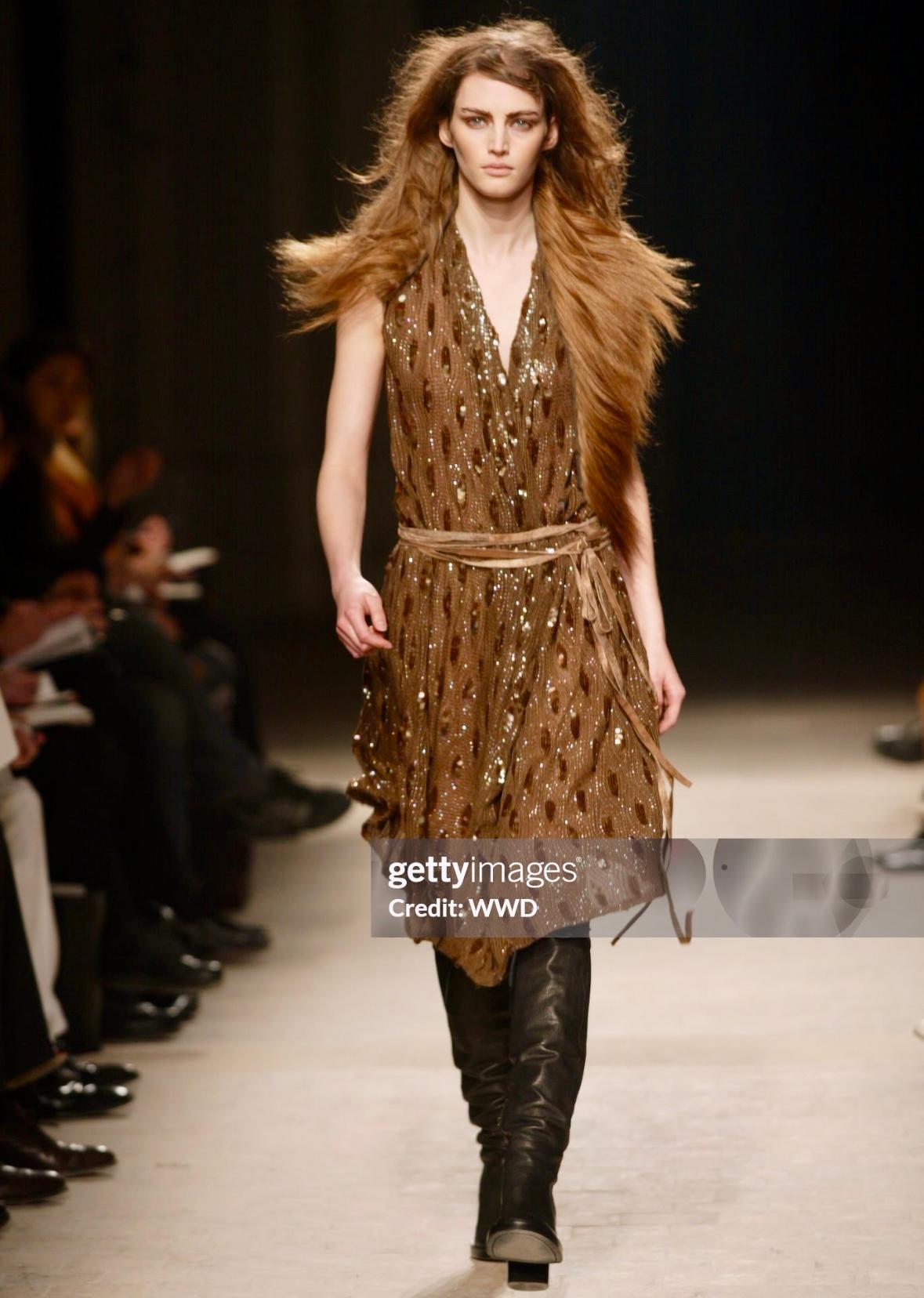 From the Fall/Winter 2002 collection, this Ann Demeulemeester mini dress is covered in grey metallic sequins in an abstract pattern and features thin black straps. A brown variation of this eye-catching dress debuted as part of look 21 on Vivien