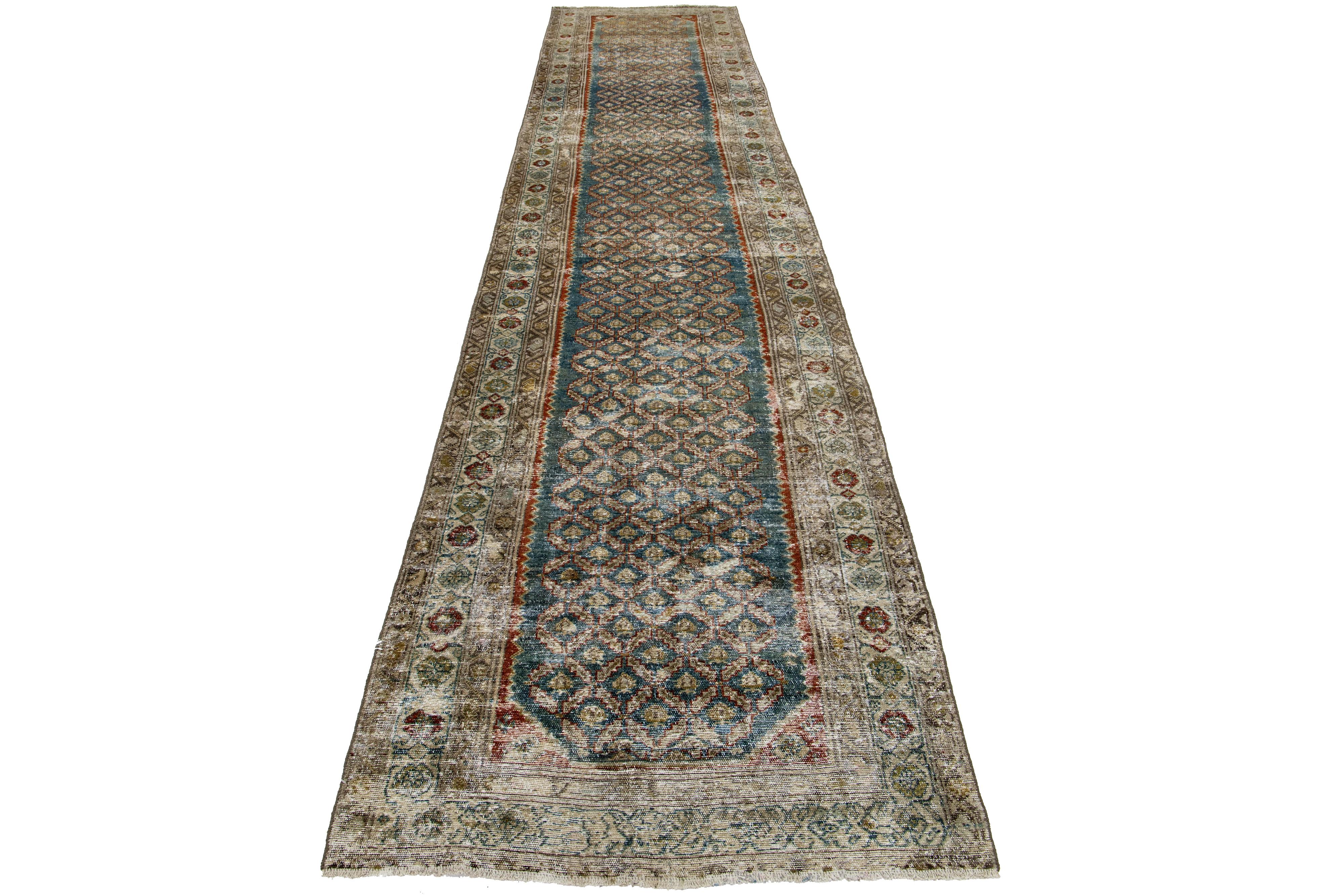 This Persian Malayer wool rug possesses an antique allure. It showcases hand-knotted wool in a blue color field. The trellis pattern is embellished with rust, brown, and golden accents.

This rug measures 3'4