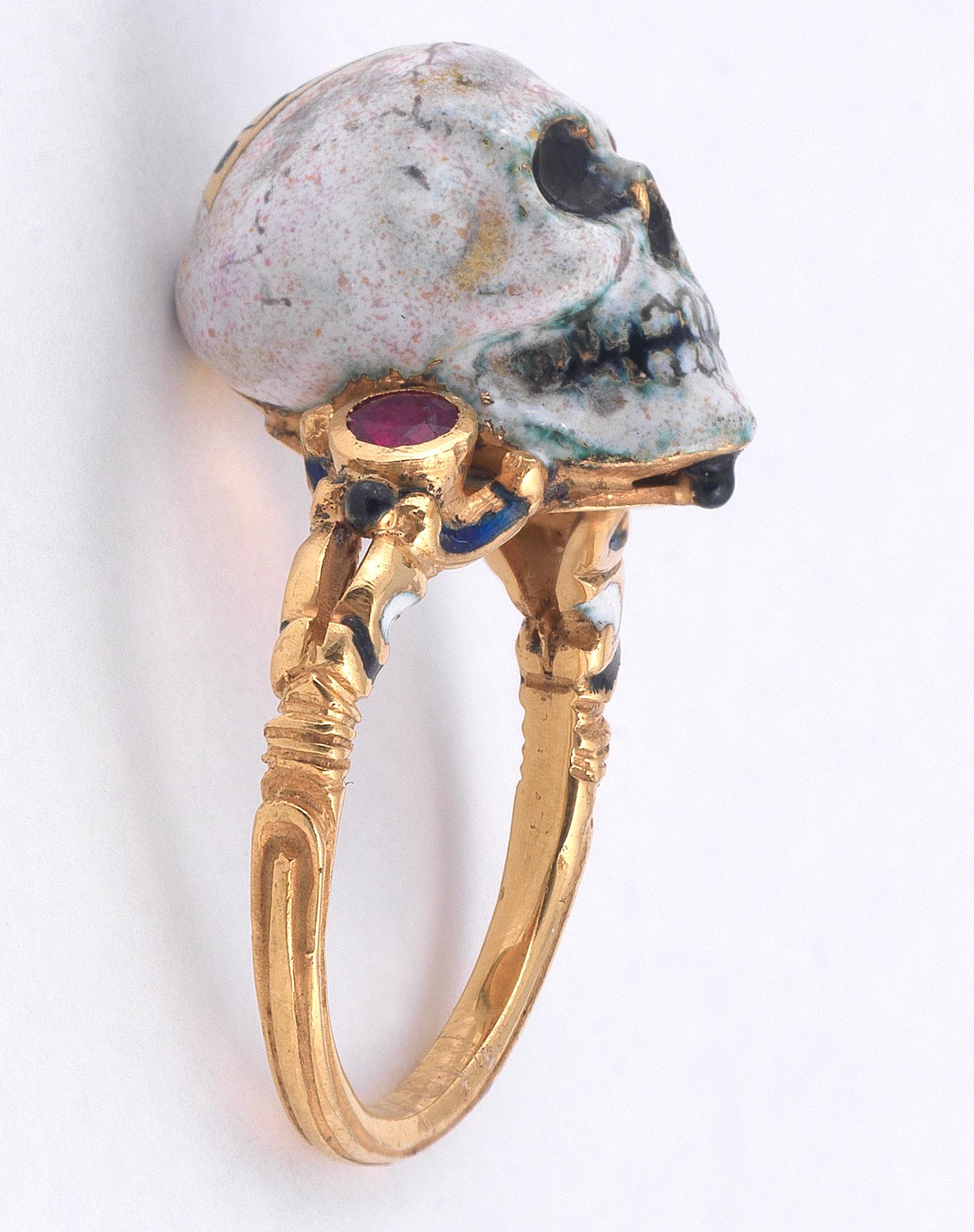 Memento Mori skull surmounted by a red enamel eye, the shoulders decorated with round rubies and multi colored enamel scrolls.

Mounted in 18Kt yellow gold 

Signed A. Codognato Venezia

Weight:  10,8 gr

Finger size: 7