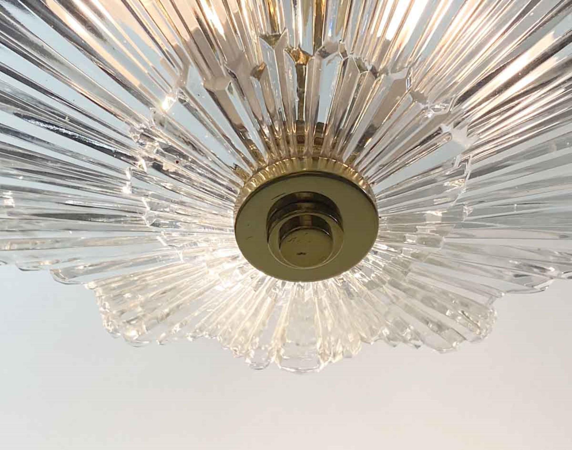 1990s Art Deco style semi flush crystal light fixture with a brass base with a Baccarat style shade. Takes three bulbs. Small hairline crack on the outer edge of the crystal in one of them which is not visible from under the light. The fixture