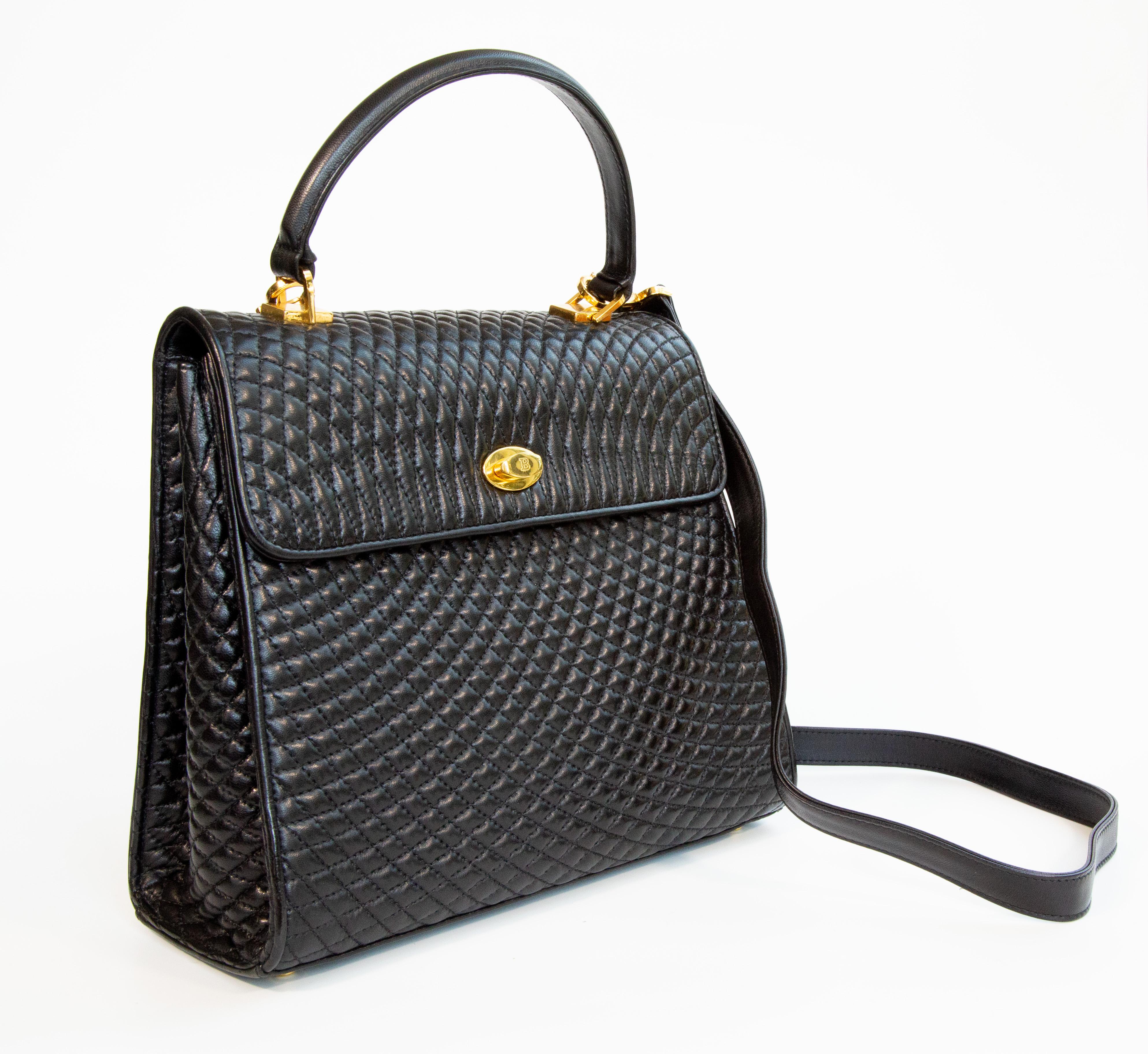 Eine Vintage Bally 2-Wege-Tasche aus schwarzem, gestepptem Leder. Die Tasche kann als Henkeltasche oder mit dem abnehmbaren Riemen (max. Länge: ca. 110 cm) als Crossbody Bag getragen werden. Die Tasche hat goldfarbene Beschläge. Der Innenraum