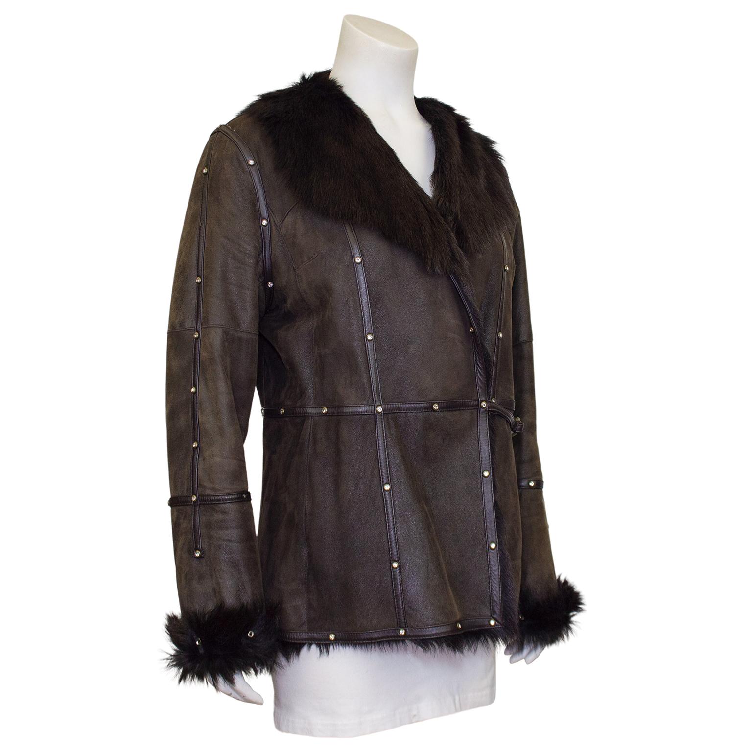 1990s Balmain short brown coat. Dark brown matte leather with dark brown fur collar, cuffs and lining. Polished brown leather trim detail creates a contrast in texture and is embellished with rhinestones in round gold tone metal settings. Small