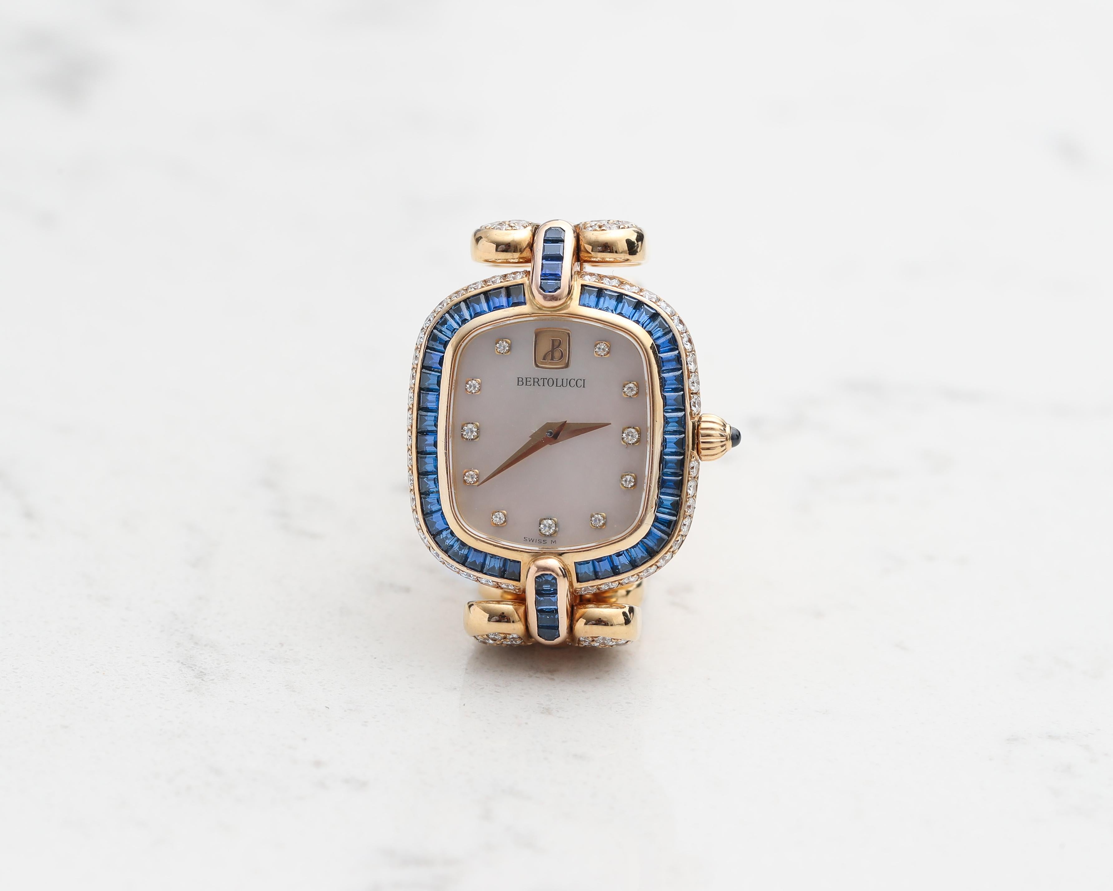 1990s Bertolucci Womens Wristwatch
Featuring Mother of Pearl Diamond Dial, crafted in 18 Karat Yellow Gold 

Diamond Details - 3 Carats, E-F Color, VVS Clarity, Round Brilliant Cut
Sapphire Details - 3 Carats, all custom cut Baguette diamonds 

Fits