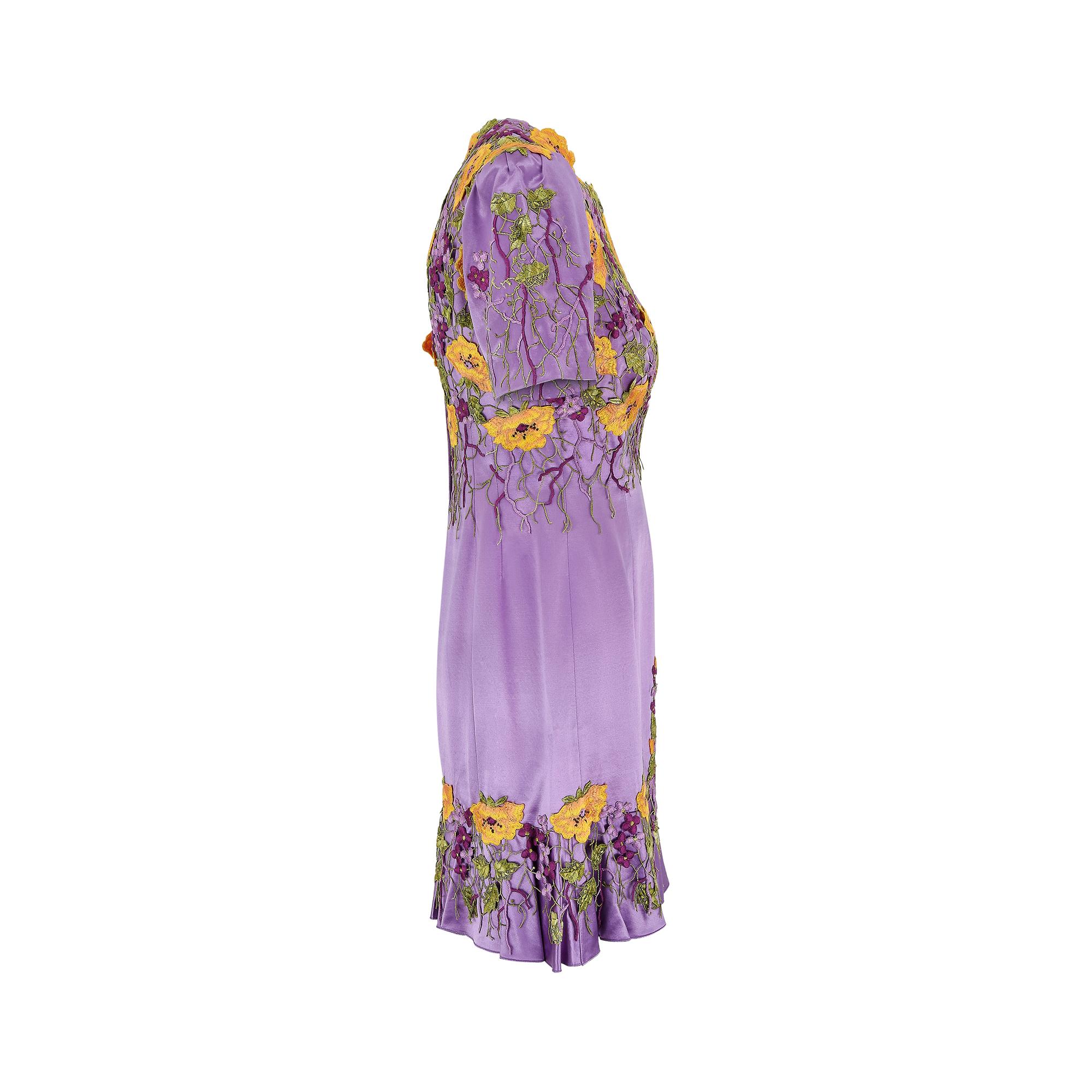 Si tratta di un abito e di una giacca swing realizzati su misura per un cliente facoltoso negli anni Novanta. La seta iridescente di colore viola pallido, che cattura la luce con sottili accenni di rosa. Le calendule arancioni, i lillà e il fogliame