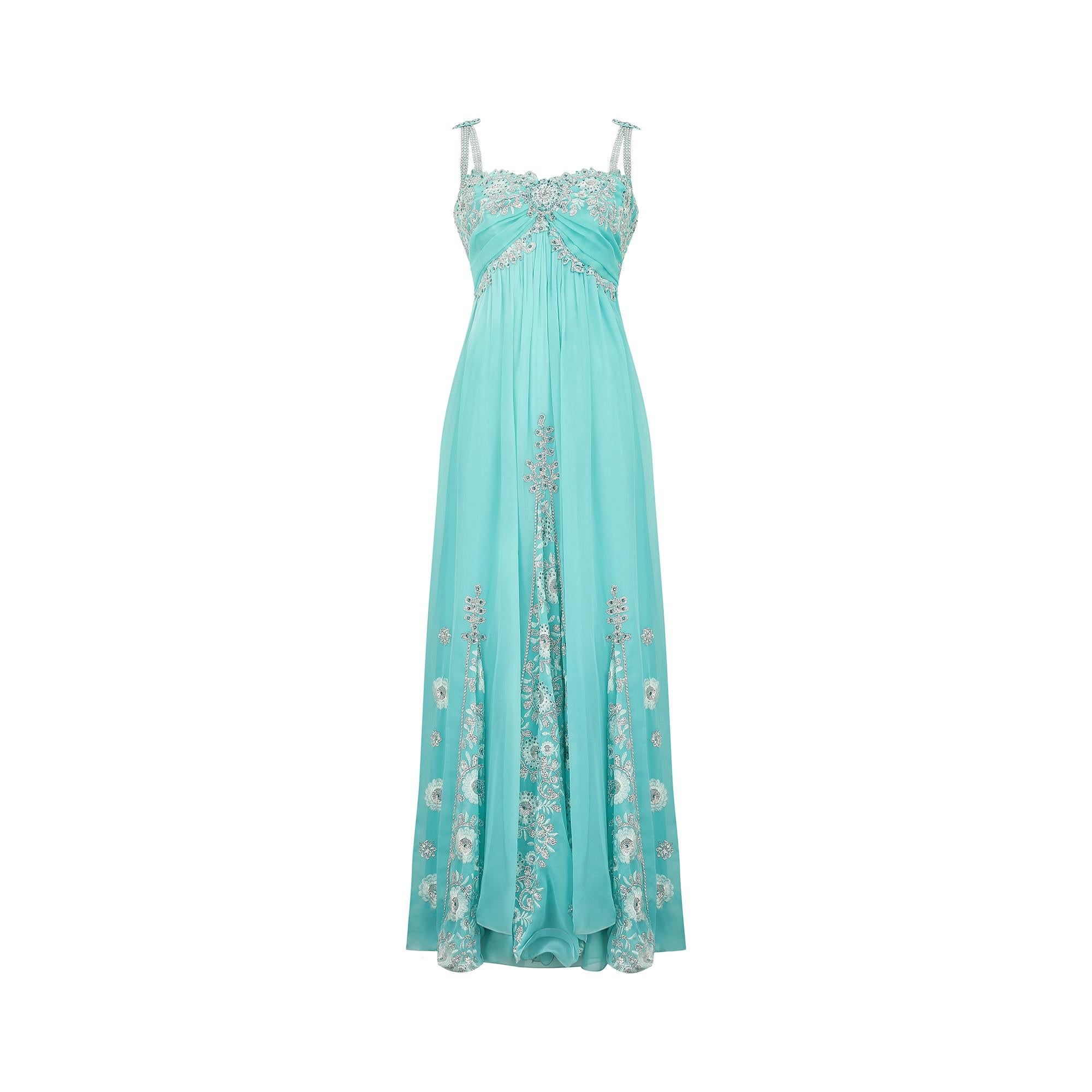 This 1990s bespoke made intricately decorated gown is crafted from the most stunning ombre shades of turquoise manmade chiffon. It features a fitted bodice with internal boning for extra shape and support. The top section has a classic sweetheart