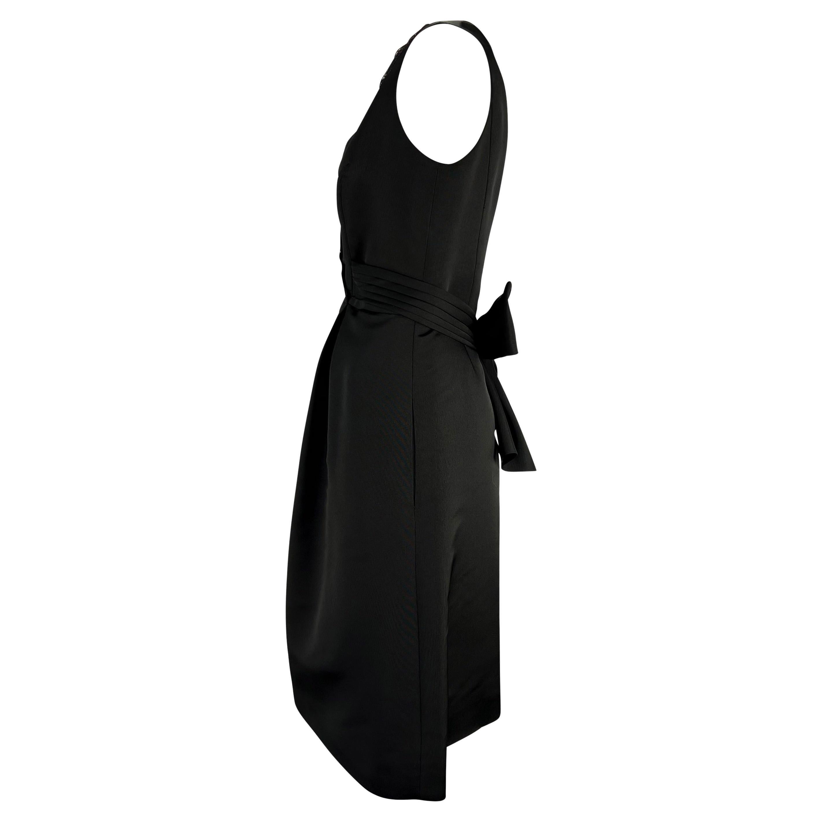 Billing présente une élégante petite robe noire vintage de Bill Blass. Datant des années 1990, cette élégante robe présente un décolleté en V doublé de dentelle, un nœud qui s'enroule autour de la taille et des poches dissimulées sur les hanches.