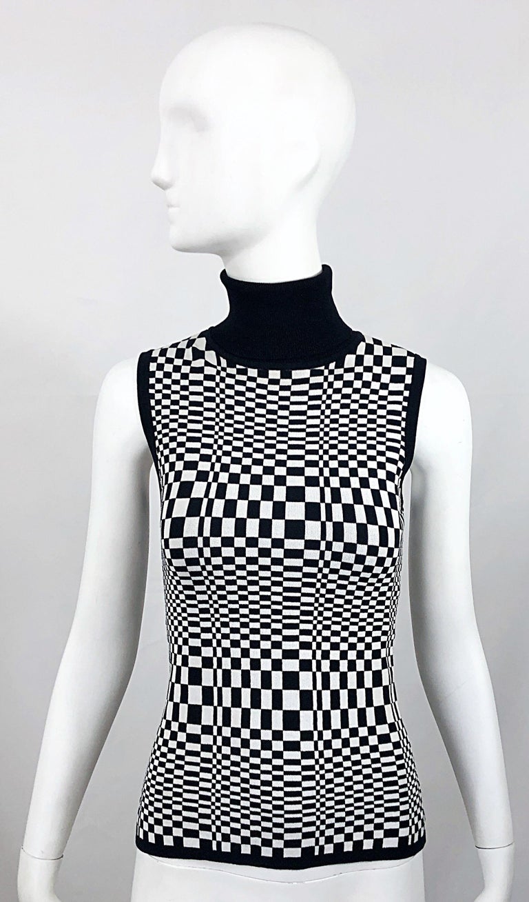 Amazing 1990s black and white op art 3-D print sleeveless knit turtleneck! Features a flattering optical illusion print throughout. Solid black neck, arm trim, and waist band. Simply slips over the head. Great belted or alone. Very well made in