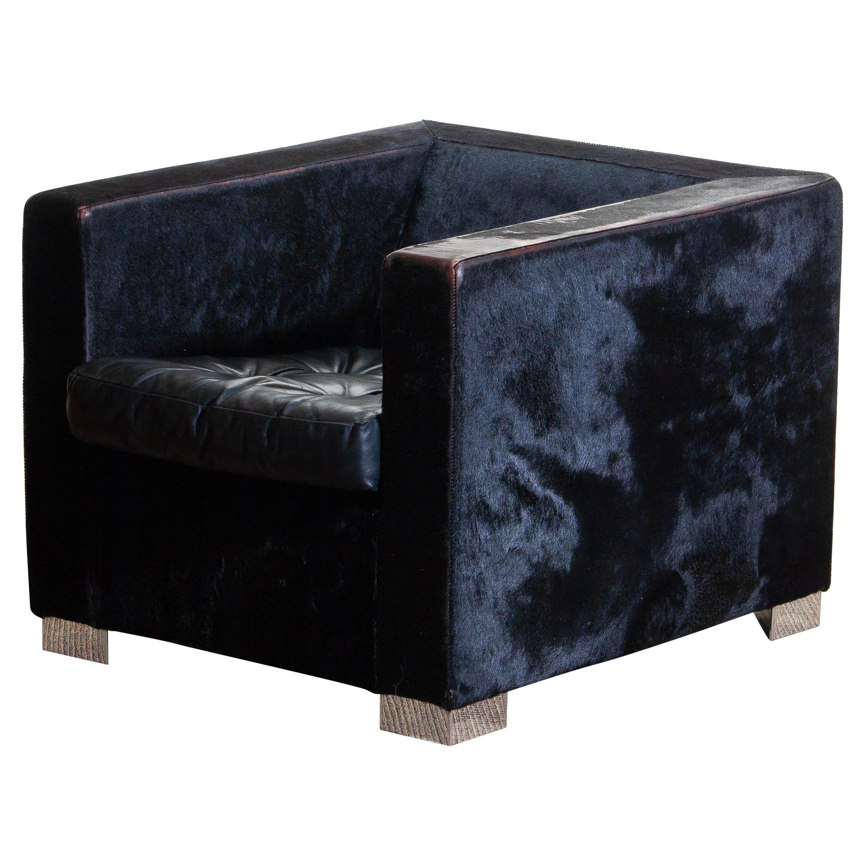 1990, contemporary “Suitcase” armchair designed by Rodolfo Dordoni for Minotti.
Upholstered with black pony and the padded seat cushion, also black, is upholstered with leather.
Standing on squared chromed metal legs.
The overall condition is