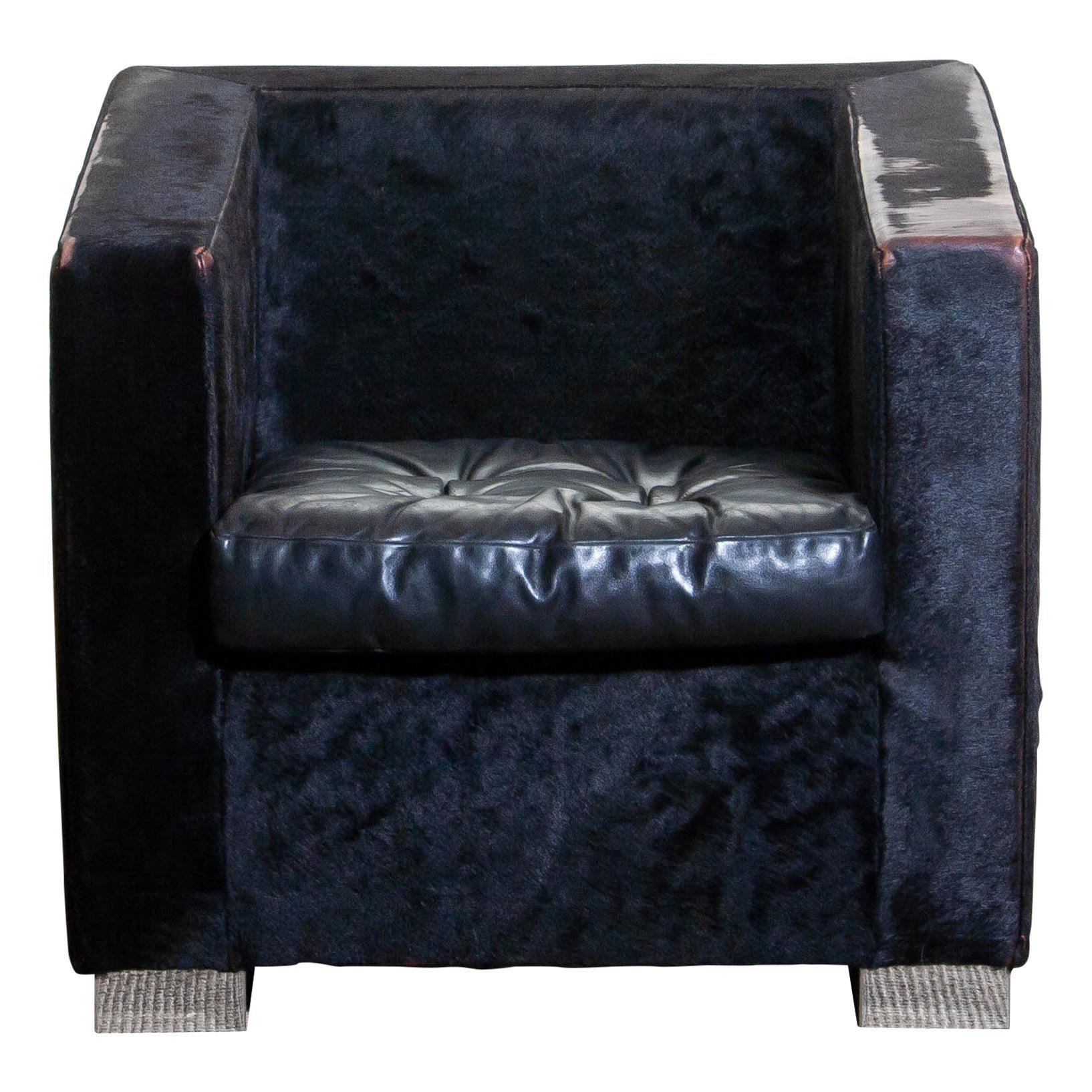 1990, contemporary “Suitcase” armchair designed by Rodolfo Dordoni for Minotti.
Upholstered with black pony and the padded seat cushion, also black, is upholstered with leather.
Standing on squared chromed metal legs.
The overall condition is
