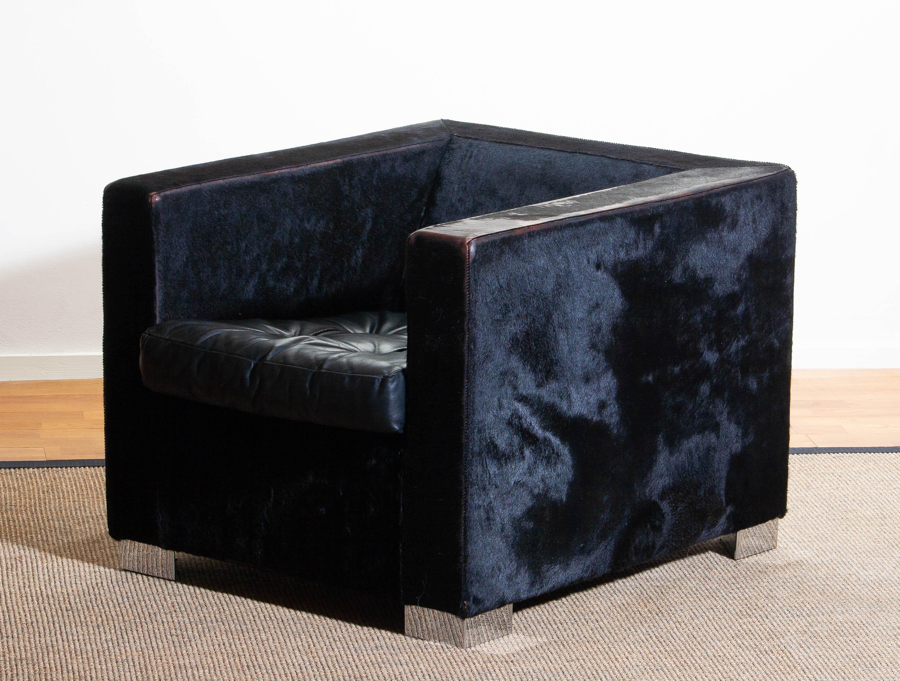 1990. Contemporary “Suitcase” armchair designed by Rodolfo Dordoni for Minotti. 
Upholstered with black pony and the padded seat cushion, also black, is upholstered with leather.
Standing on squared chromed metal legs.
The overall condition is