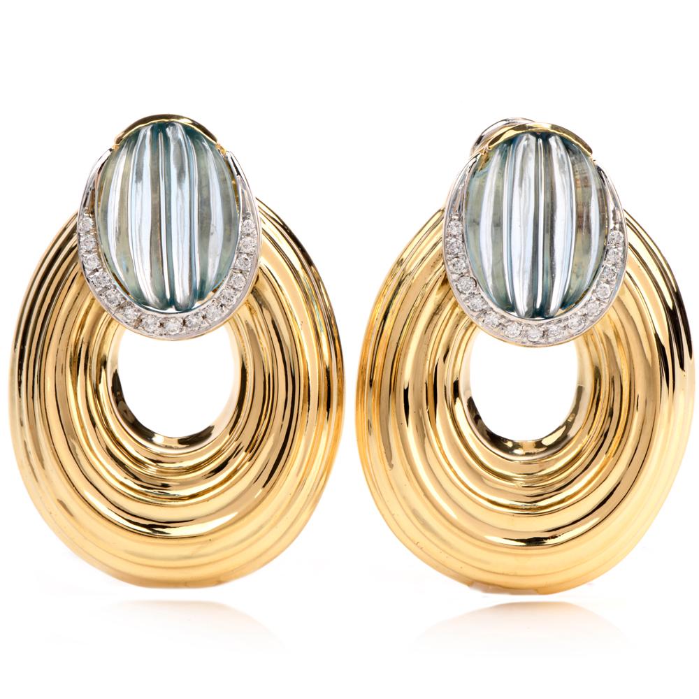 These beautiful italian blue topaz and diamond earrings are crafted with 18-karat yellow gold, weighing 41.4 grams and measuring 42mm long x 29mm wide. Showcasing a pair of bezel-set fancy-oval shaped blue topaz with a rigid lines, weighing