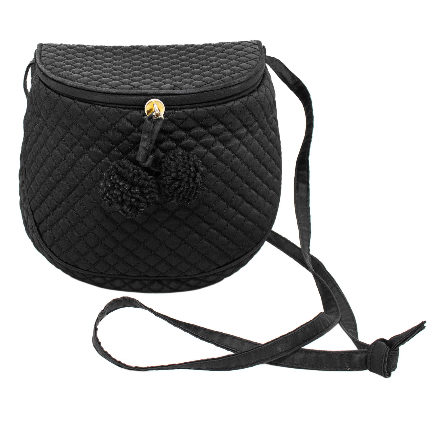 Lovely Bottega Veneta mailbag from the 1990s. Black quilted satin with black top stitching. Demi lune shape with two black pom poms. Black satin interior. The long, thin black strap can be used on the shoulder or crossbody, or it can be pulled