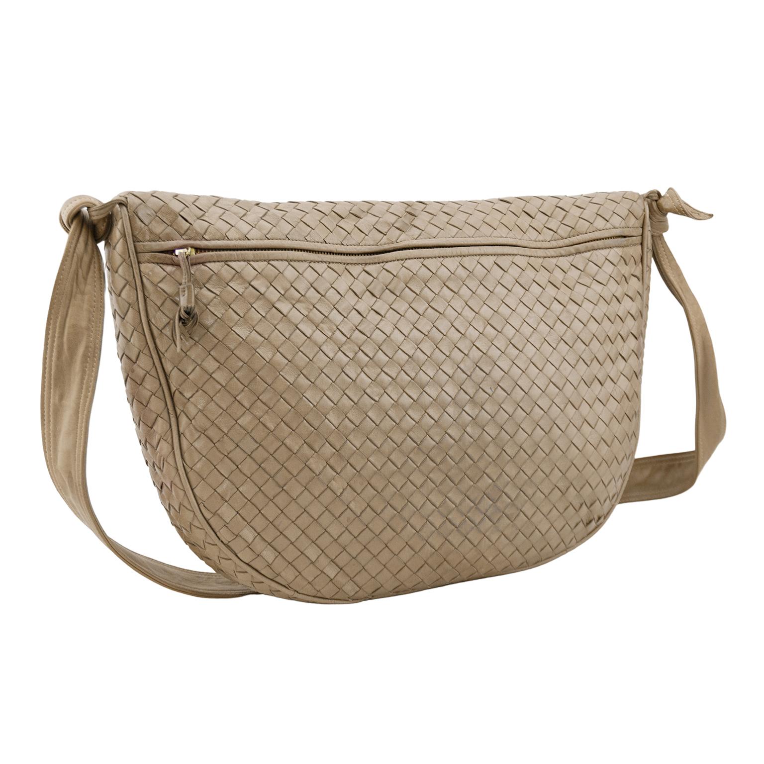 Beautiful 1990s Bottega Veneta hobo bag. Taupe intrecciato leather with matching taupe leather crossbody strap. Strap features monochromatic top stitching and knot details. Large slit pocket with zipper on front and small slit pocket with zipper on