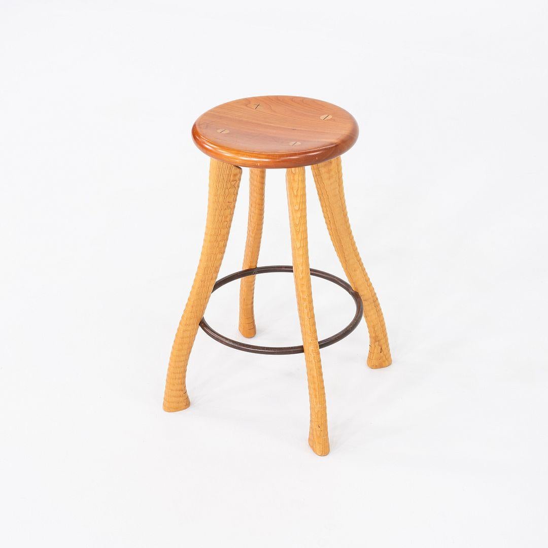 Questo è uno sgabello da banco Studio A, realizzato da Brad Smith per Bradford Woodworking nel 1990 circa. La base è composta da quattro maniglie Ax in legno di frassino, mentre la seduta è in legno di ciliegio a contrasto. È un pezzo interessante