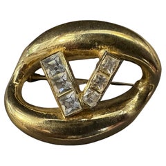 An Iconic 1990s Brass and Strass Logo Brooch by Valentino