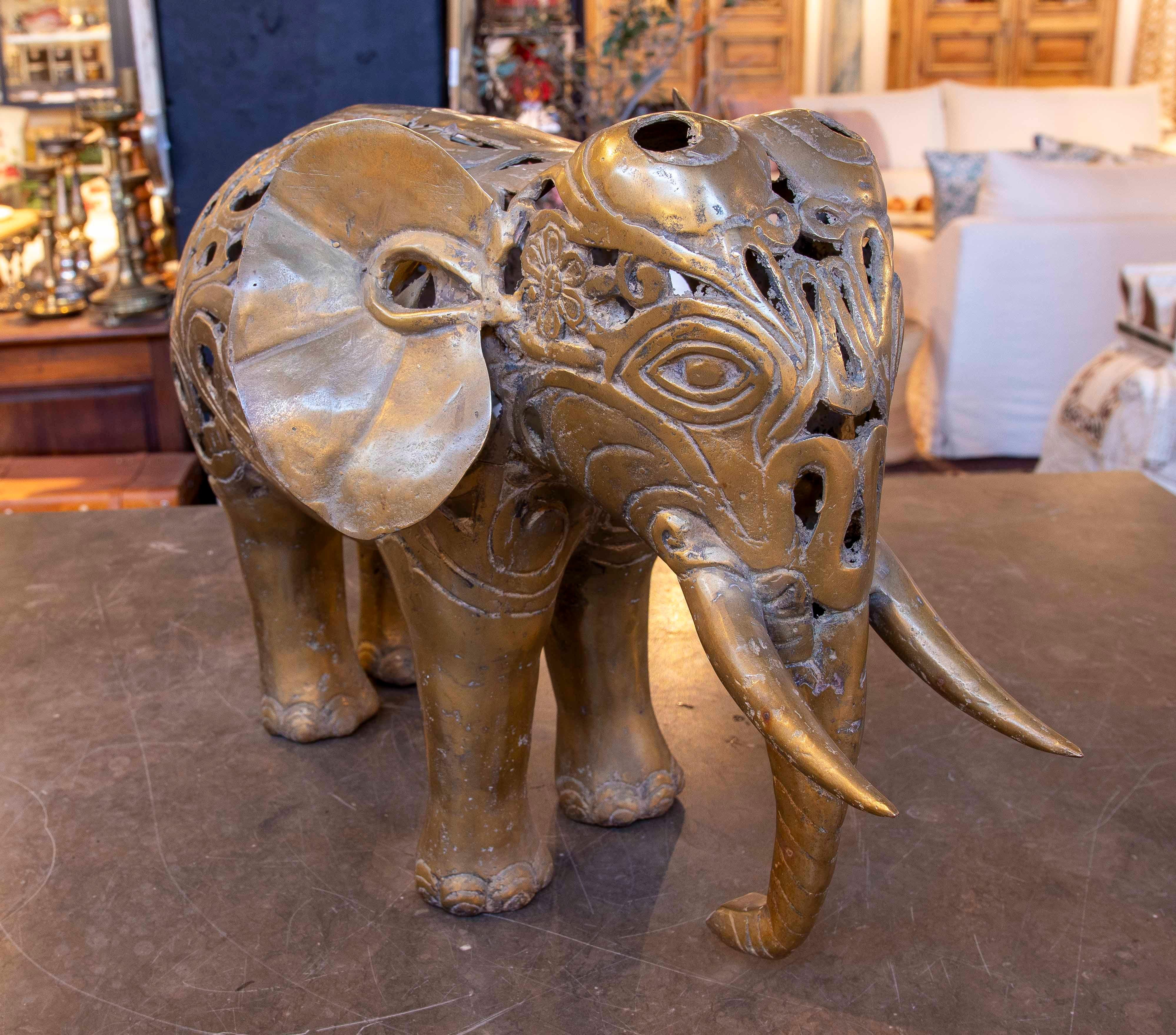 Diese Elefanten-Skulptur aus Bronze zeichnet sich durch ein zartes, durchbrochenes Design mit floralen Motiven und dekorativen Mustern aus. Seine fein ausgearbeiteten Merkmale, darunter breite Ohren, gebogene Stoßzähne und sorgfältig modellierte
