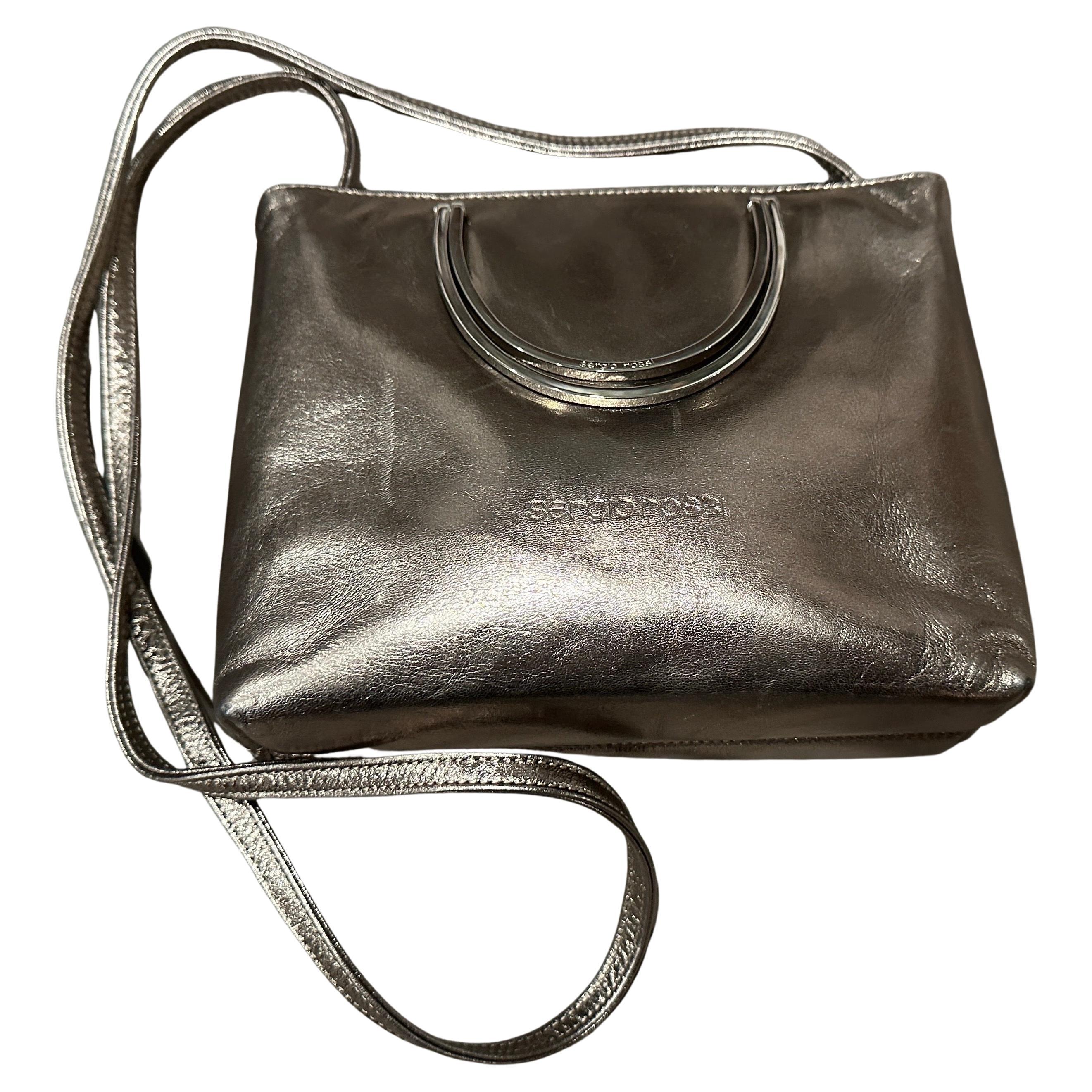 Elegante bolso vintage de los años 90 de Sergio Rossi en piel metalizada color bronce con herrajes plateados
Impresionante y versátil bandolera vintage del célebre diseñador italiano Sergio Rossi, de la década de 1990. Conocidas por su excepcional