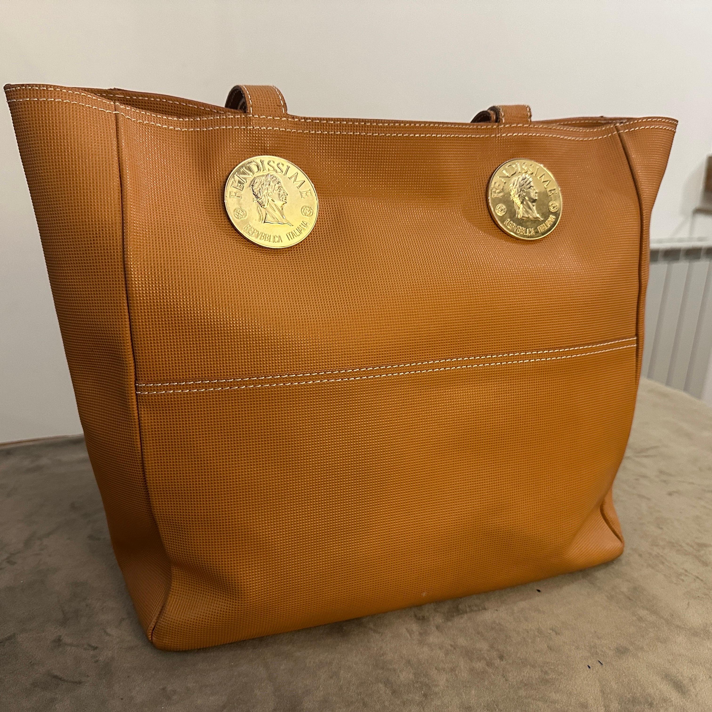 This is a 1990s brown leather tote bag by Fendissime, a diffusion line by the luxury brand Fendi. The bag features a soft rectangular silhouette with dual top handles. The leather appears to have a textured finish, giving it a refined look. A
