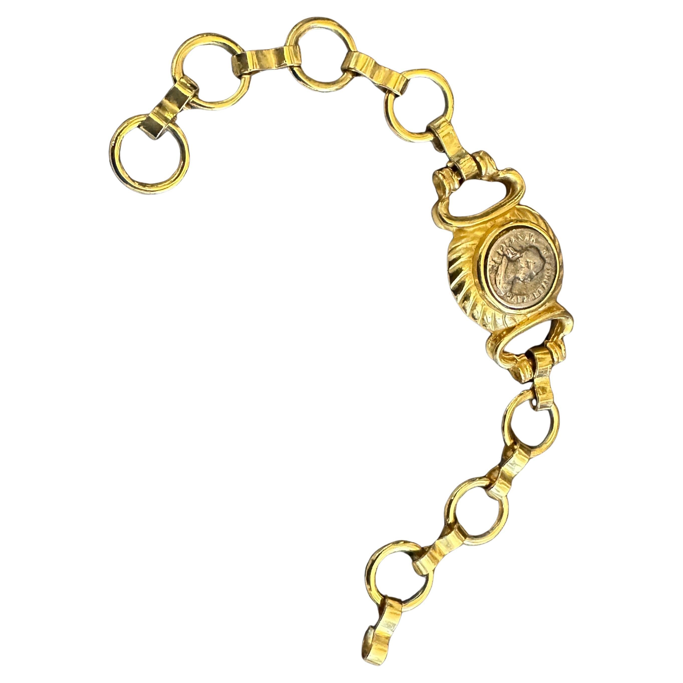 This striking Neo-Classical style bracelet, inspired by the iconic Bulgari Monete collection, is a perfect statement piece from the 1990s. The design is a bold tribute to ancient history, featuring polished brass metalwork that evokes the richness