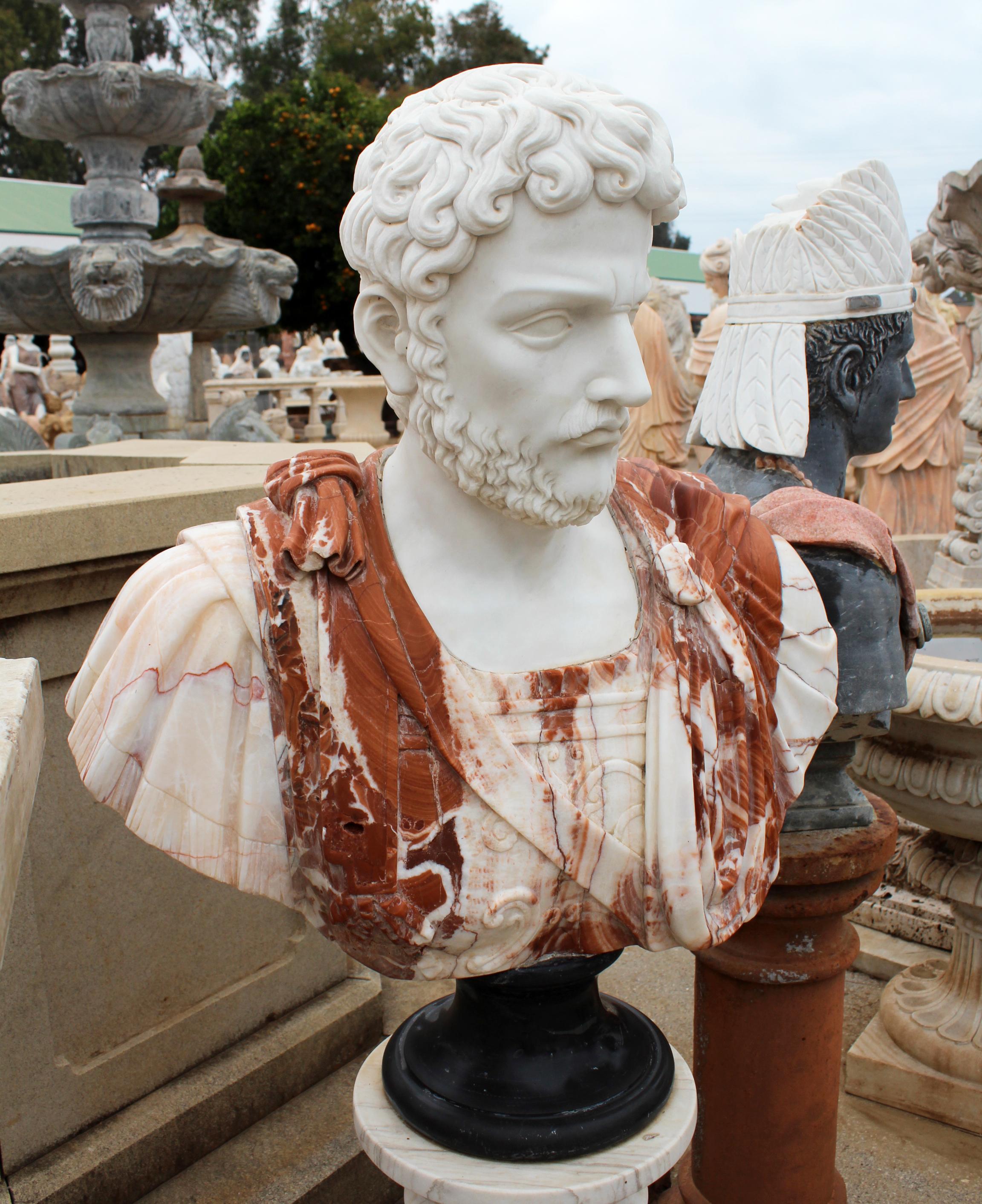 1990s bust of a Roman general, hand carved by craftsmen using Carrara white marble for the head and Alicante red for the toga, where the white and red contrast give movement and realism to the cloth. It stands on a simple round base in Belgian black