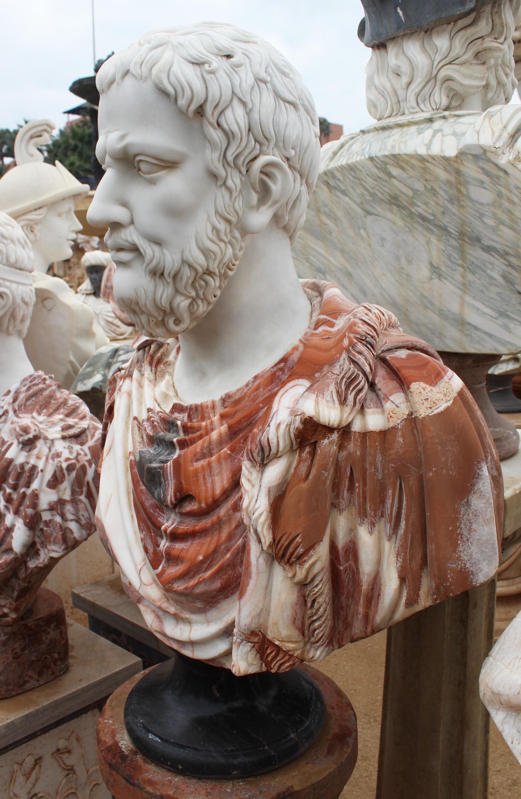 1990s bust of a Roman, hand carved by craftsmen using Carrara white marble for the head and Alicante red for the toga, where the white veins give movement and realism to the cloth. Simple round base in Belgian black marble.