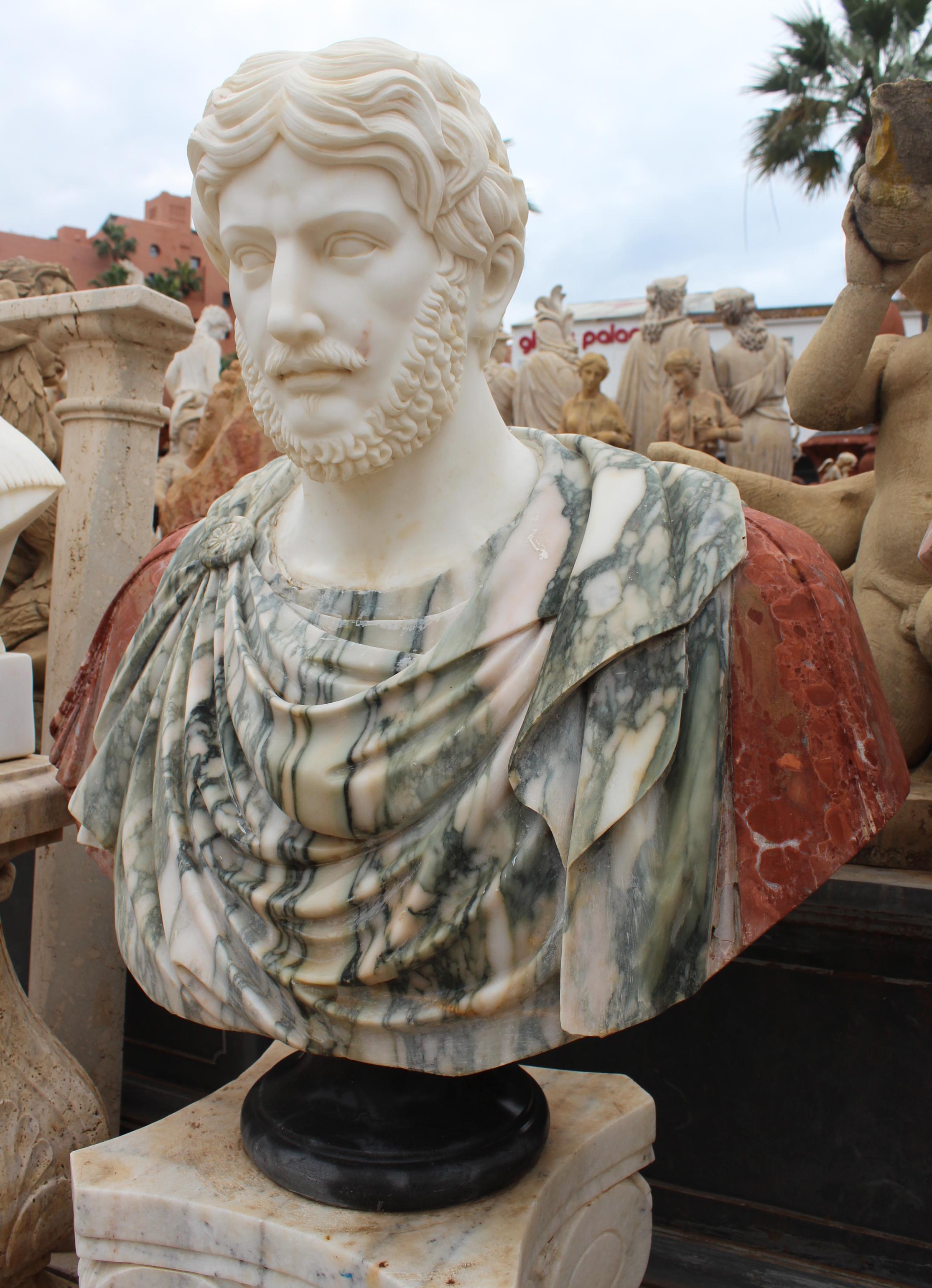 1990s bust of a Roman, hand carved by craftsmen using Carrara white marble for the head, Arabescato for the main toga body and Alicante red for the arms, where the veining provide realist texture and movement to the cloth. Simple round base in
