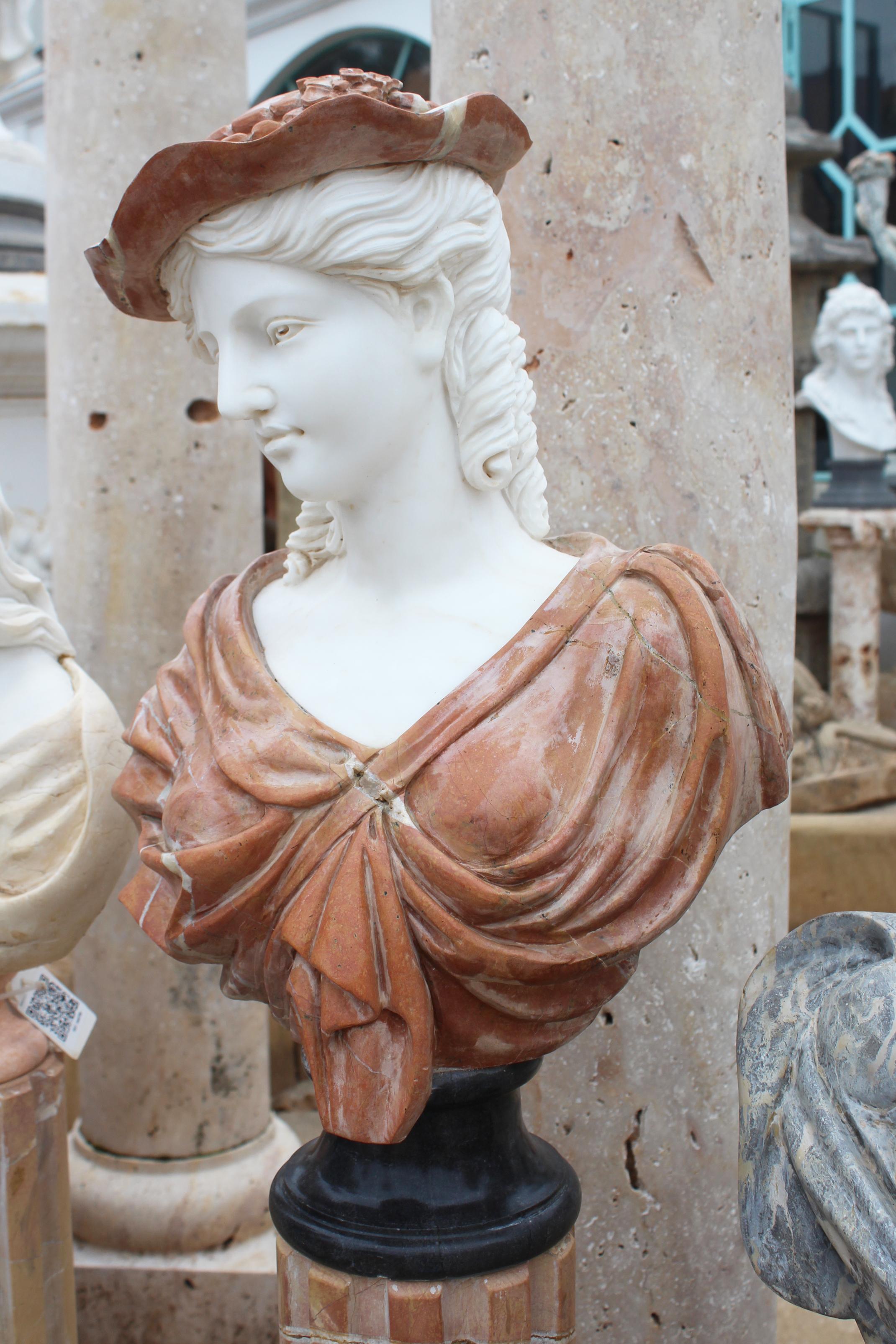 1990s Bust of a woman, hand carved by craftsmen using Carrara white marble for the head and Alicante red for the toga and hut, where the white veins give movement and realism to the cloth. Simple round base in Belgian black marble.
 