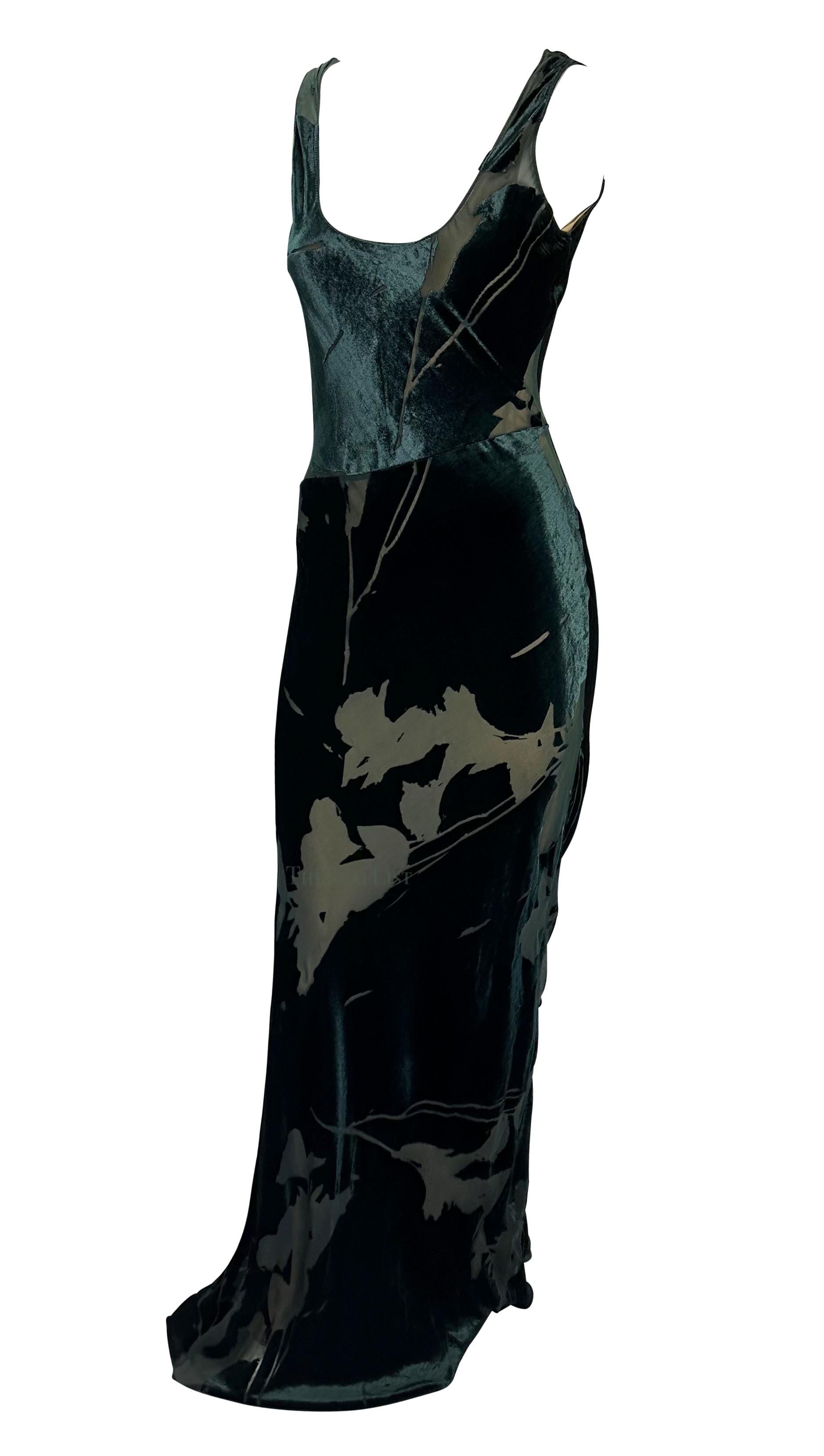 TheRealList presents: a fabulous green floral Calvin Klein slip gown. From the 1990s, the dress is covered in an enchanting devoré velvet floral print. Its sleeveless design, enhanced by a flattering scoop neckline, exudes understated elegance,