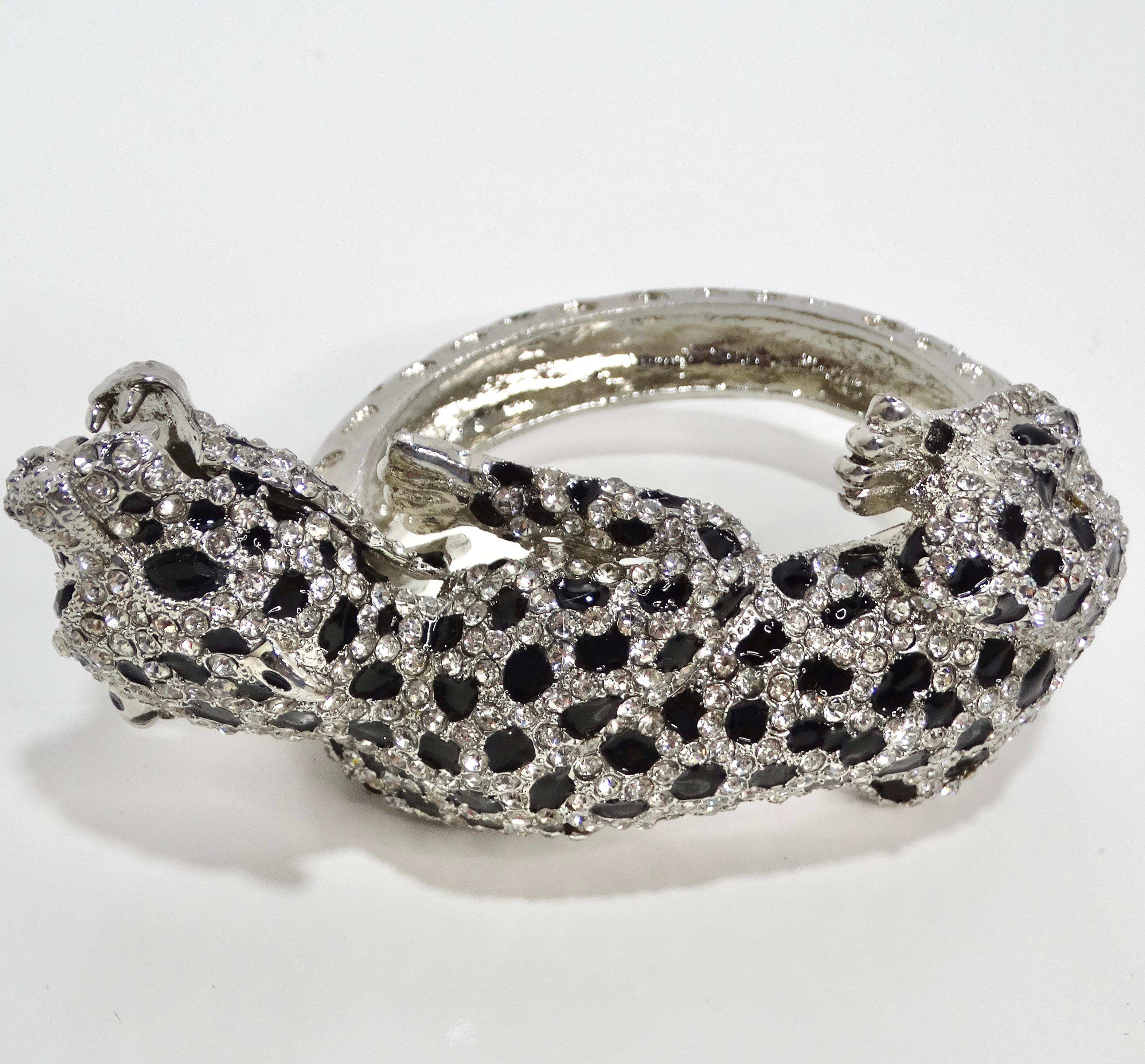 Introducing the 1990s Cartier Inspired Rhinestone Panther Cuff Bracelet, a stunning and glamorous accessory that exudes elegance and sophistication. Crafted from silver-plated metal, this cuff bracelet features a large panther motif adorned with