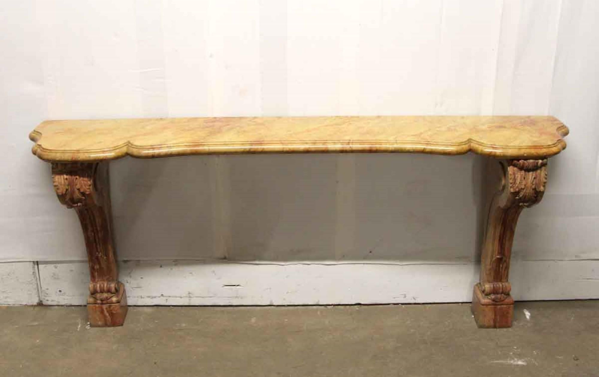 1990s carved marble entry side table or console with corbel sides and decorative details and a faux marble serpentine top. This can be seen at our 400 Gilligan St location in Scranton, PA.