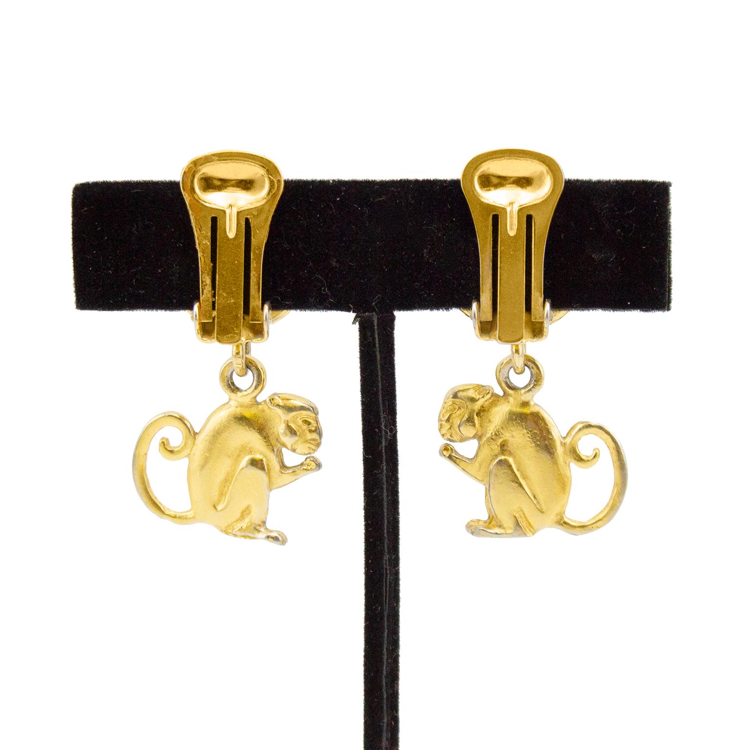 Stunning 1990's Celine clip on earrings. Gold tone metal buttons, engraved with Celine Paris. Drop monkey pendants facing each other. Celine and Made in Italy markings on interior. Vintage condition/patina - wear throughout to the gilt metal with