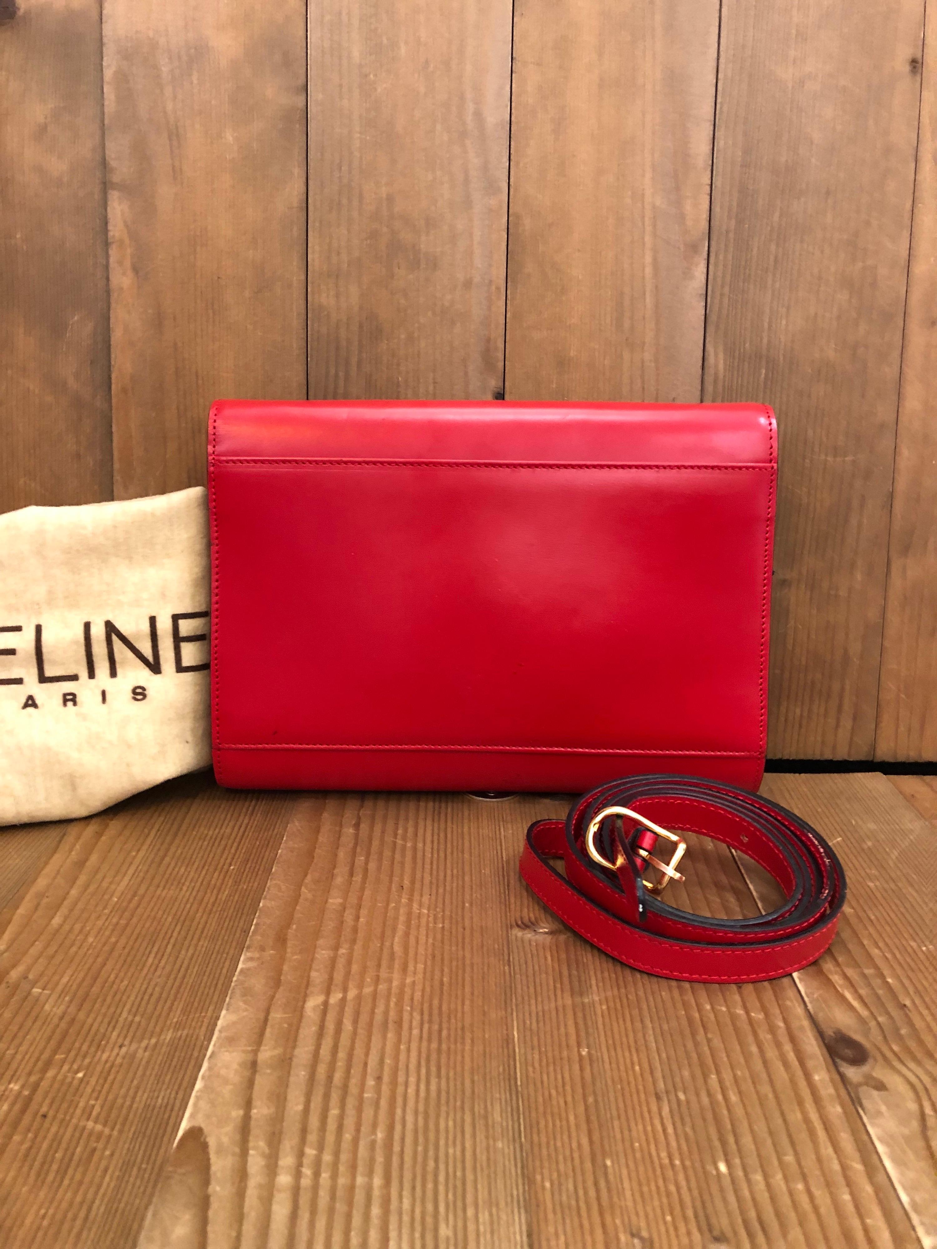 1990s Celine Two-Way Ring Bag in red leather featuring one exterior open pocket and one interior zip pocket. It can be worn as shoulder/crossbody bag or carried as a clutch. Made in Italy. Measures 9.75 x 7 x 1.5 inches. Comes with dust bag and