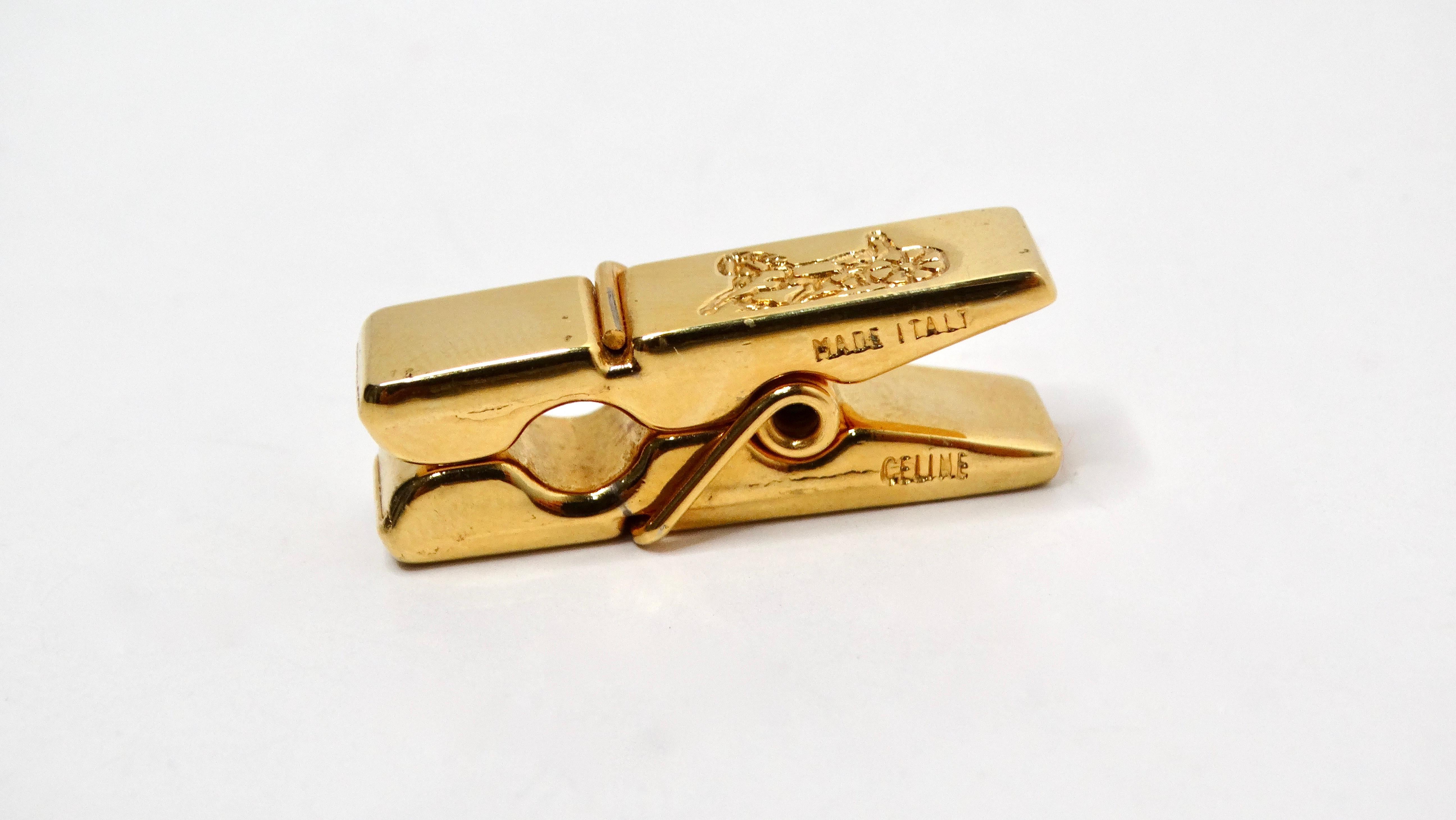 The 1990s Celine Gold-Tone Clothespin Style Tie Clip is a stunning accessory that perfectly embodies the luxe aesthetic of that era. Featuring a striking motif of the Celine logo, which showcases a beautifully crafted horse-drawn carriage, this tie