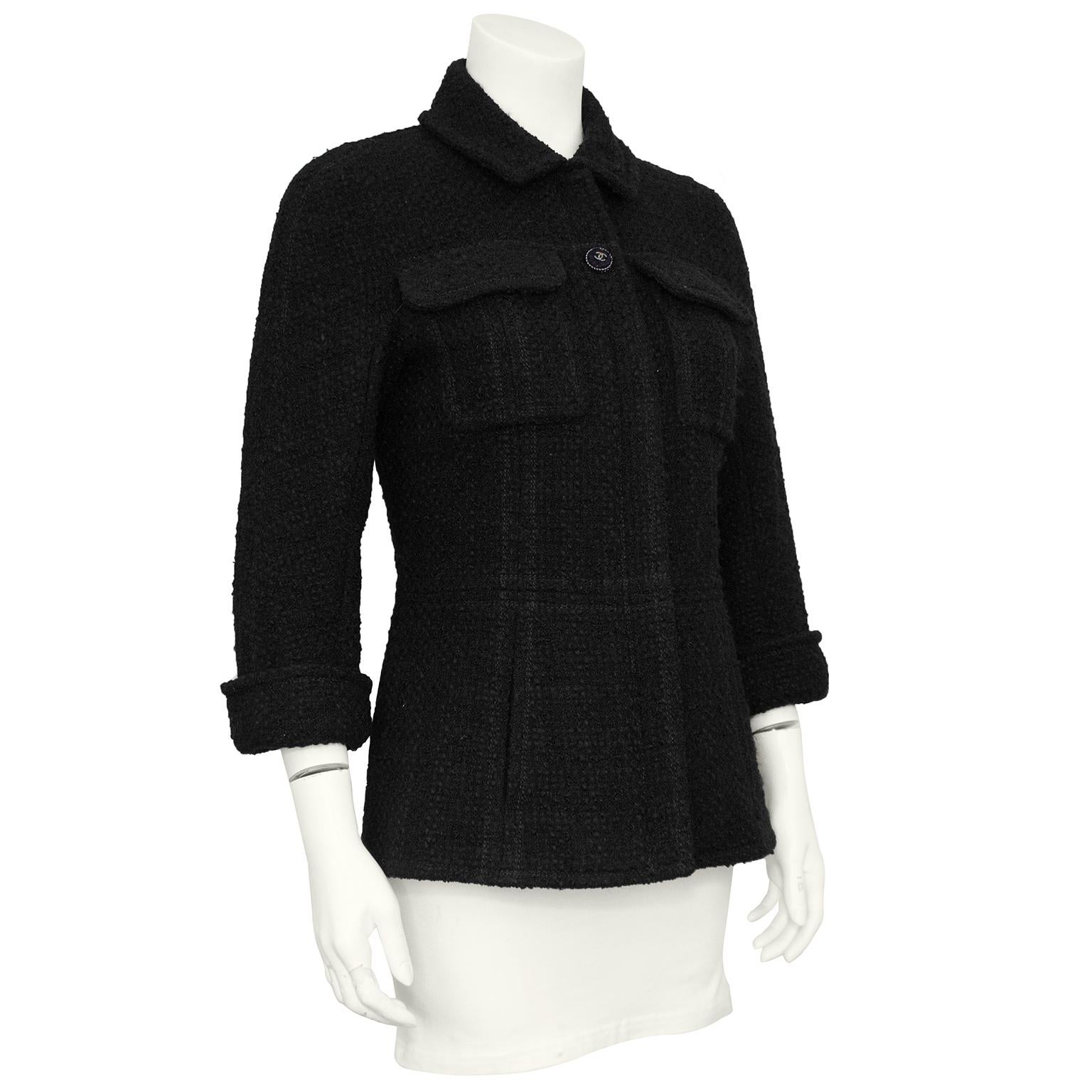 Beautiful and timeless Chanel jacket. Black boucle with patch pockets at the bust, vertical slit pockets at hips and bracelet length rolled sleeves. Buttons at cuffs and top centre button are dark silver with matching black boucle. The rest buttons