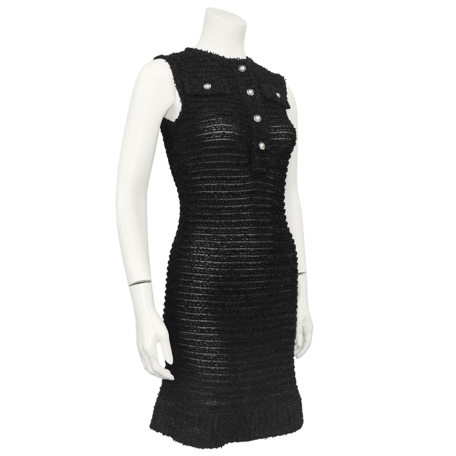A fun twist on a classic Chanel dress! Mid 20000s Chanel black boucle open knit sheer dress. Sleeveless with a henley neckline and faux flap pockets. The black is contrasted by the pearl logo buttons encased in lucite. Can be worn with a slip under