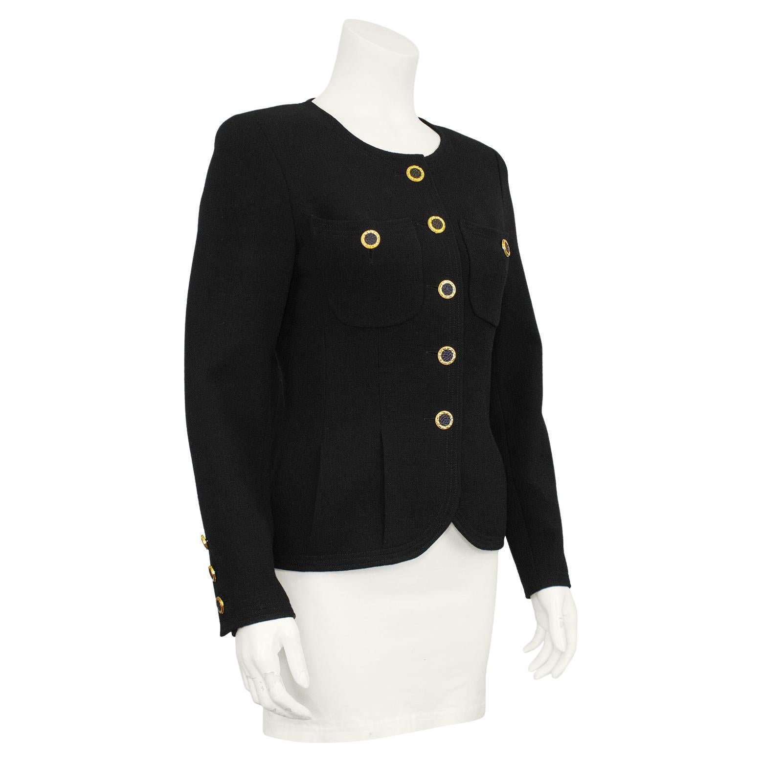 Lovely textured black crepe Chanel jacket from the 1990s. Collarless with contrasting gold tone and black buttons and two patch pockets at the bust. The beautiful seam work throughout and inverted pleats at the hips make this jacket very flattering