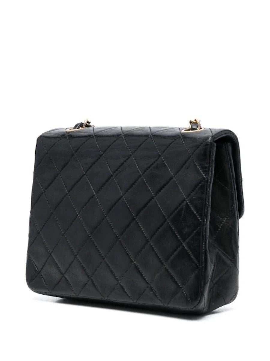 Chanel by Karl Lagerfeld black Mini Timeless quilted lambskin shoulder bag featuring a quilted pattern, gold-plated hardware with iconic 'CC' front closure, metal and leather interwoven shoulder and crossbody strap, burgundy leather lining an inside