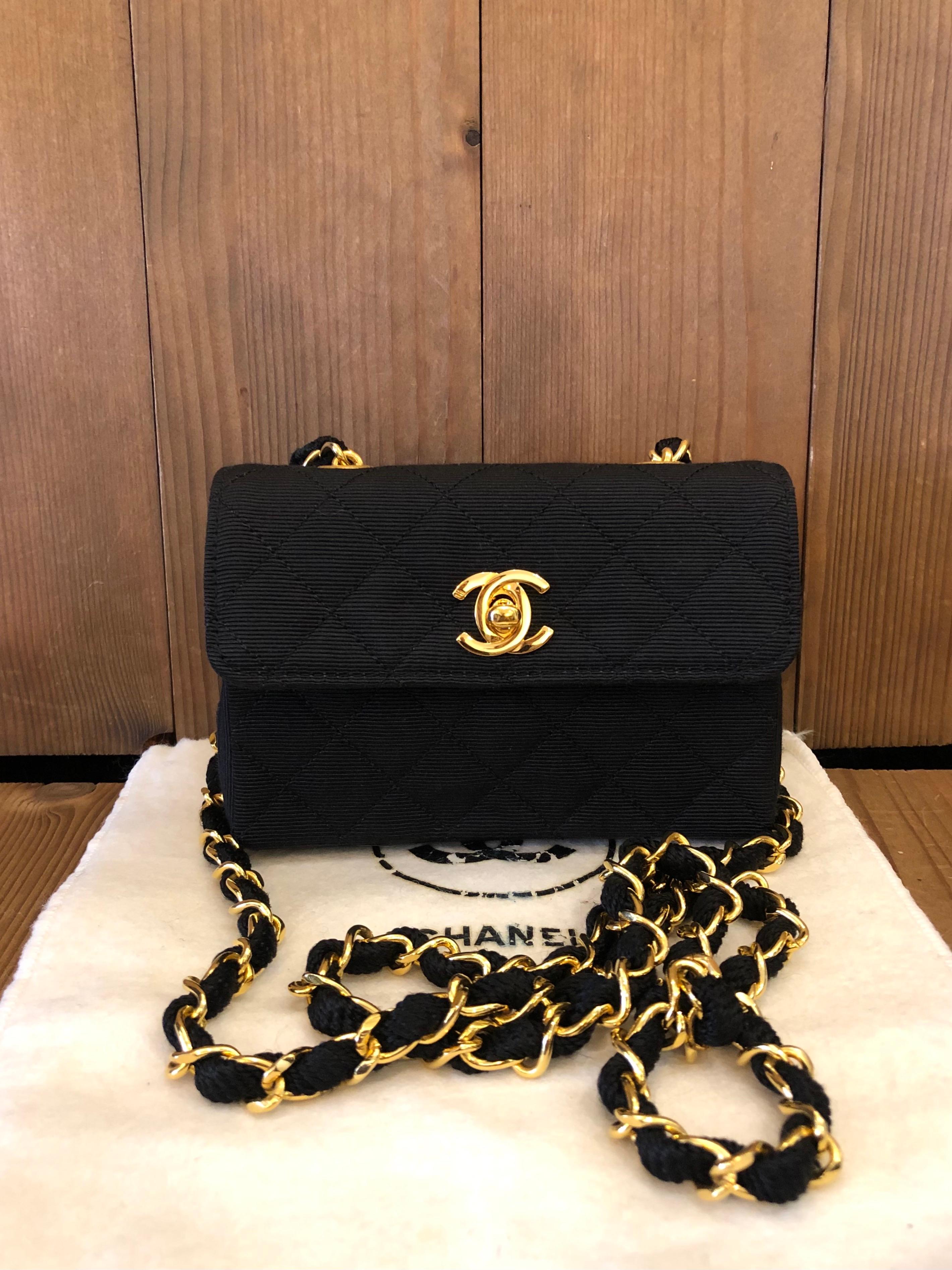 1990s Chanel mini flap bag in black canvas and gold hardware featuring a gold toned crossbody chain interlaced with the same fabric. Made in France. Rectangular body measures 5.5 x 3.75 x 1.75 inches Chain drop 19 inches. Comes with dust bag.