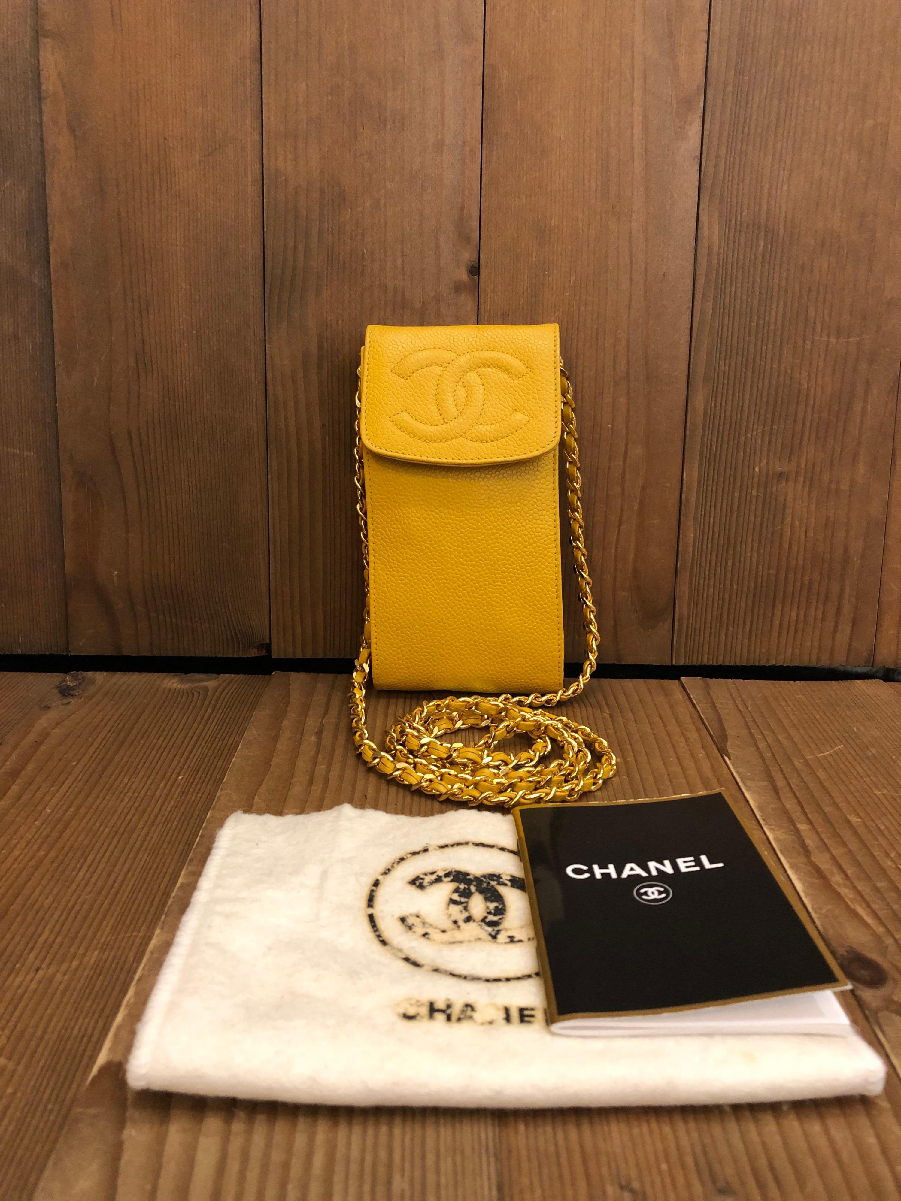 This vintage CHANEL chain pouch is crafted of caviar calfskin leather in yellow featuring a gold toned crossbody chain interlaced with the same leather. Made in France. Measures approximately 6.5 x 3.25 x 1 inches Chain drop 23 inches. Holo 4