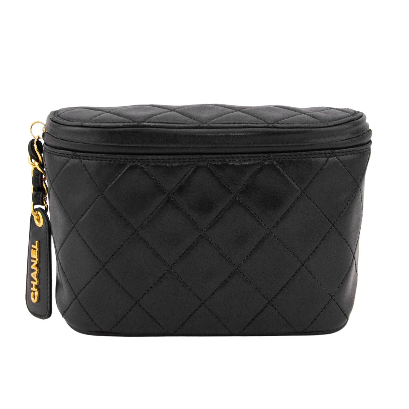 Beautiful 1990s Chanel waist bag with all the classic and iconic Chanel features. Supple black quilted lambskin leather with a zipper across the front. Zipper features a black leather and gold tone metal chain zipper tab with an oversized black
